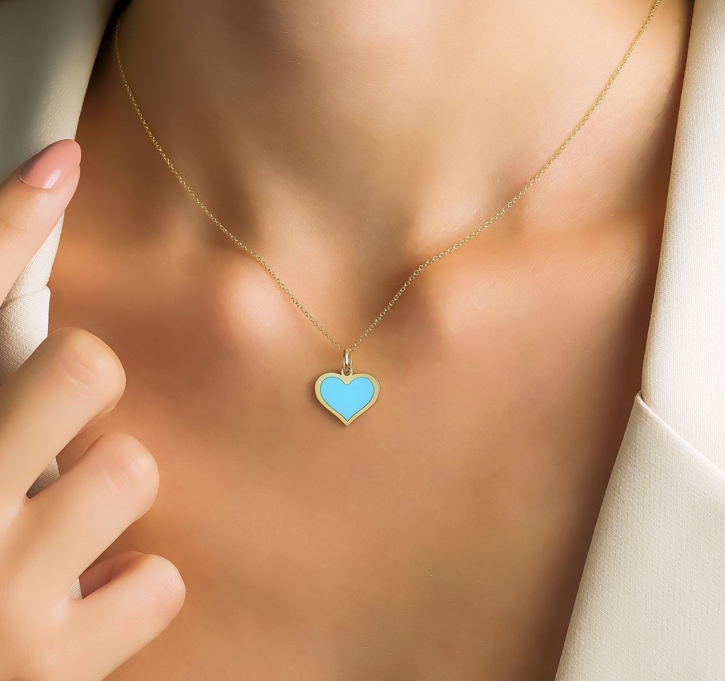 14K yellow gold turquoise heart pendant necklace worn by a model with a chic outfit.