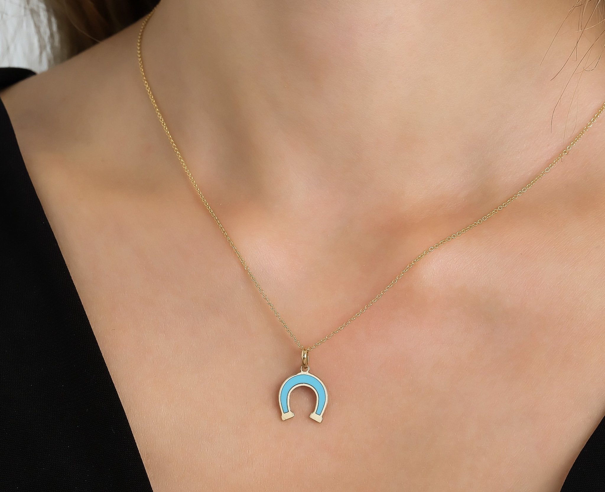 14K yellow gold turquoise horseshoe necklace worn by a model, showcasing its delicate design.