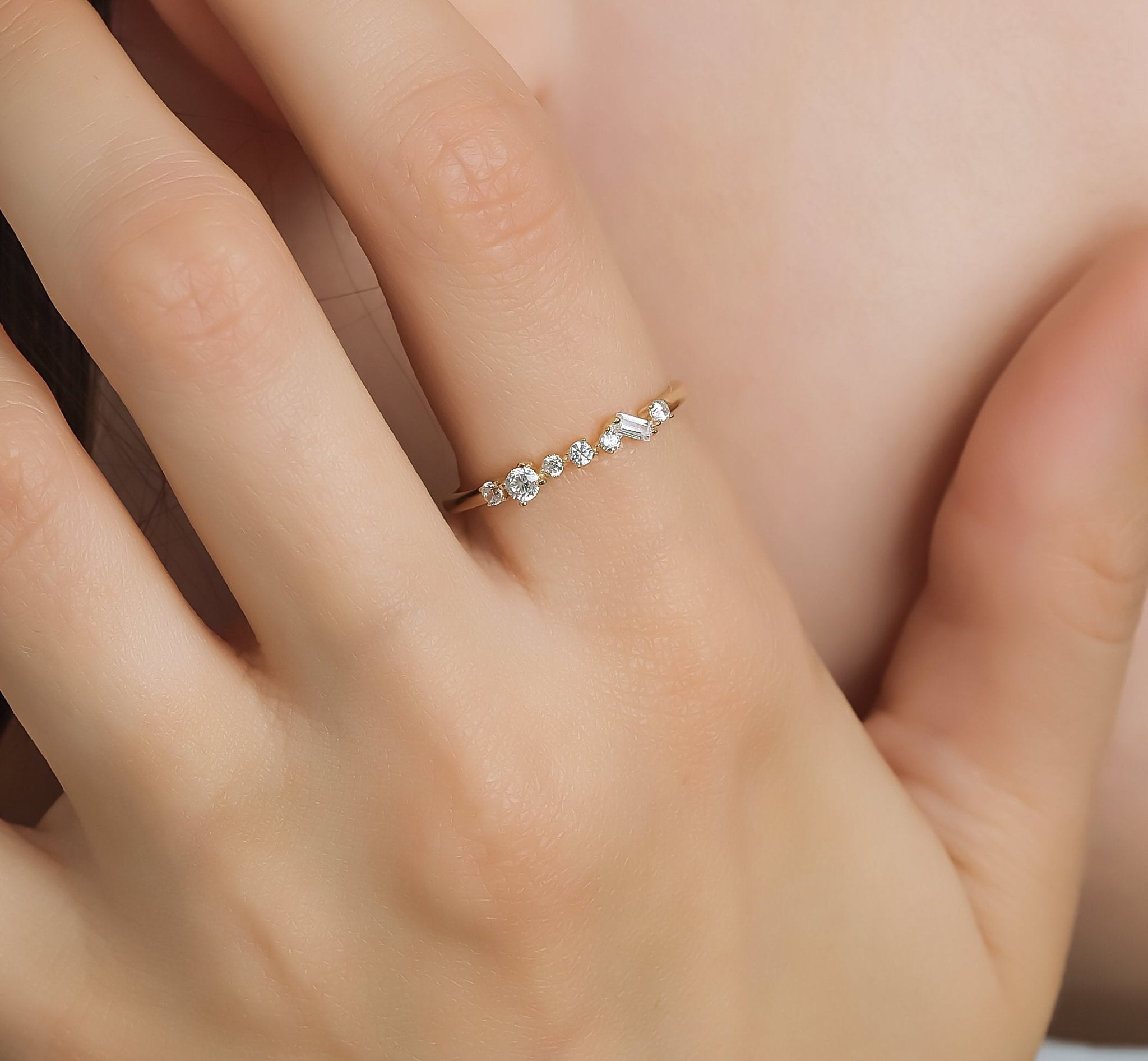 14K yellow gold women's wedding band with CZ stones, stunning cluster design, 1.5mm width, elegantly displayed on a hand.