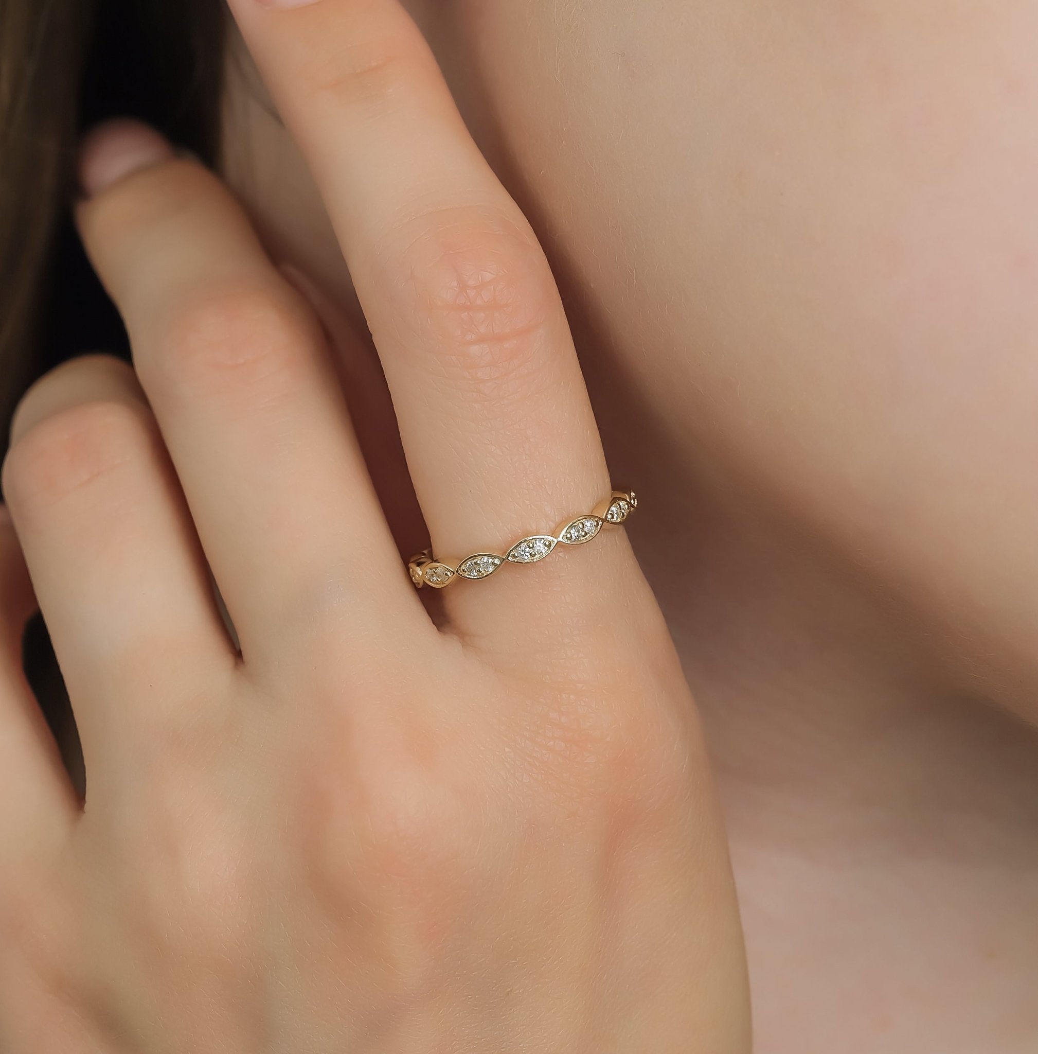 14K yellow gold half eternity diamond wedding band featuring round diamonds, showcased on a hand with a close-up view.