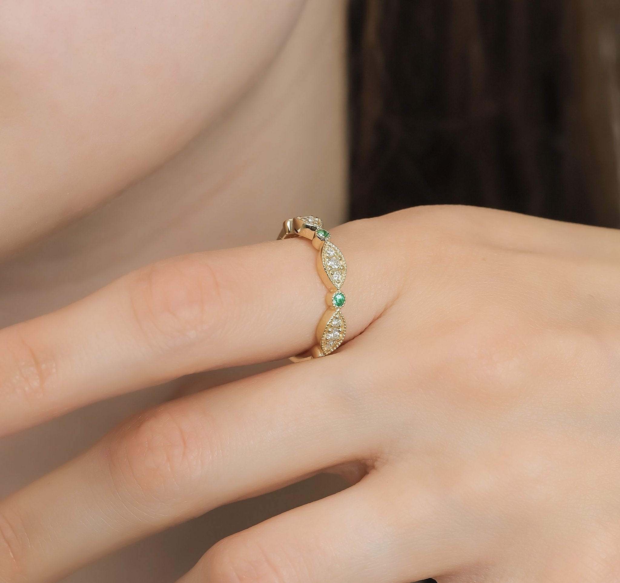 14K yellow gold ring featuring emeralds and diamonds, showcasing a modern design with shiny finish and delicate detailing.