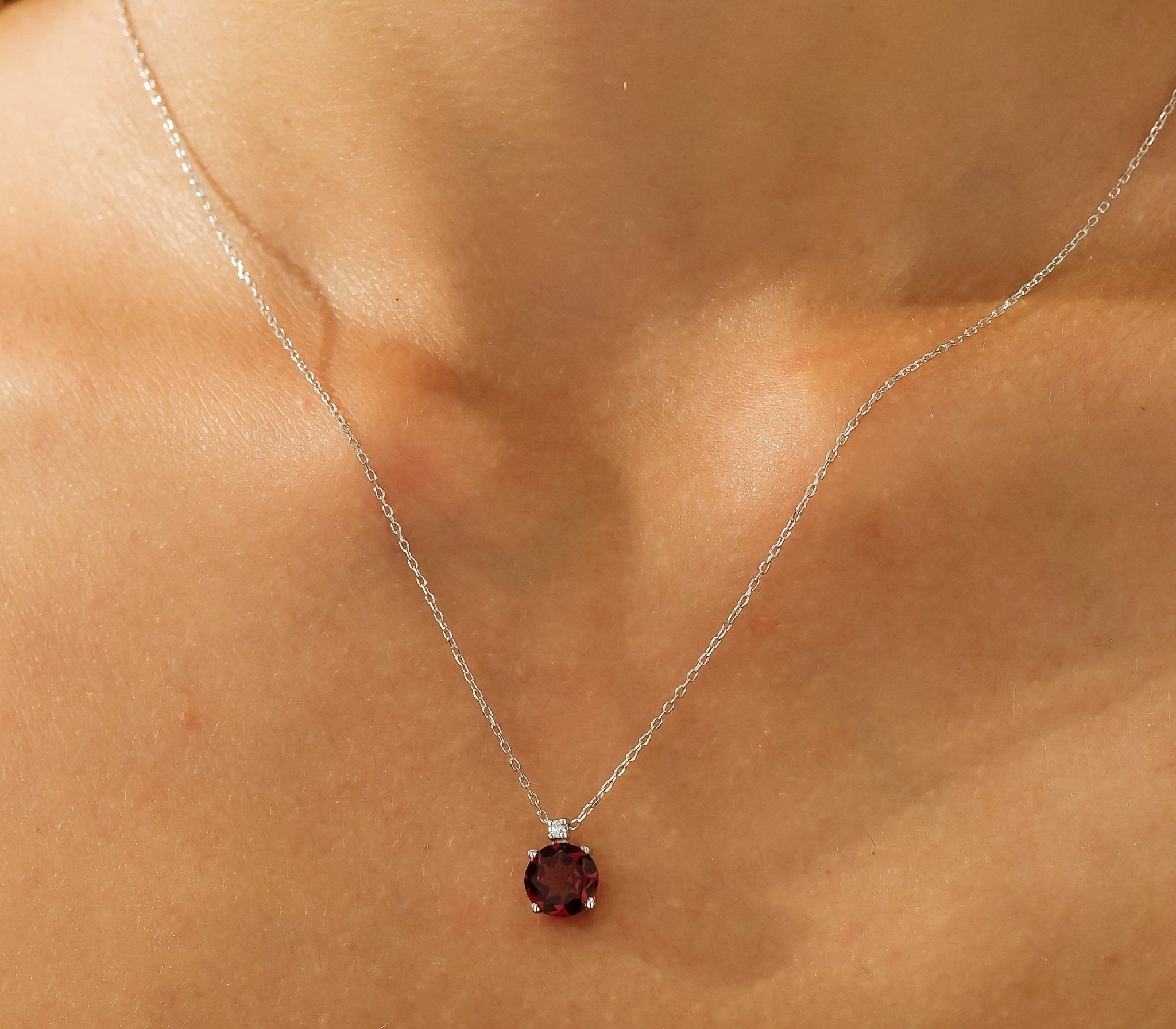 14K white gold natural garnet and diamond solitaire necklace on a person, showcasing its elegance and simplicity.