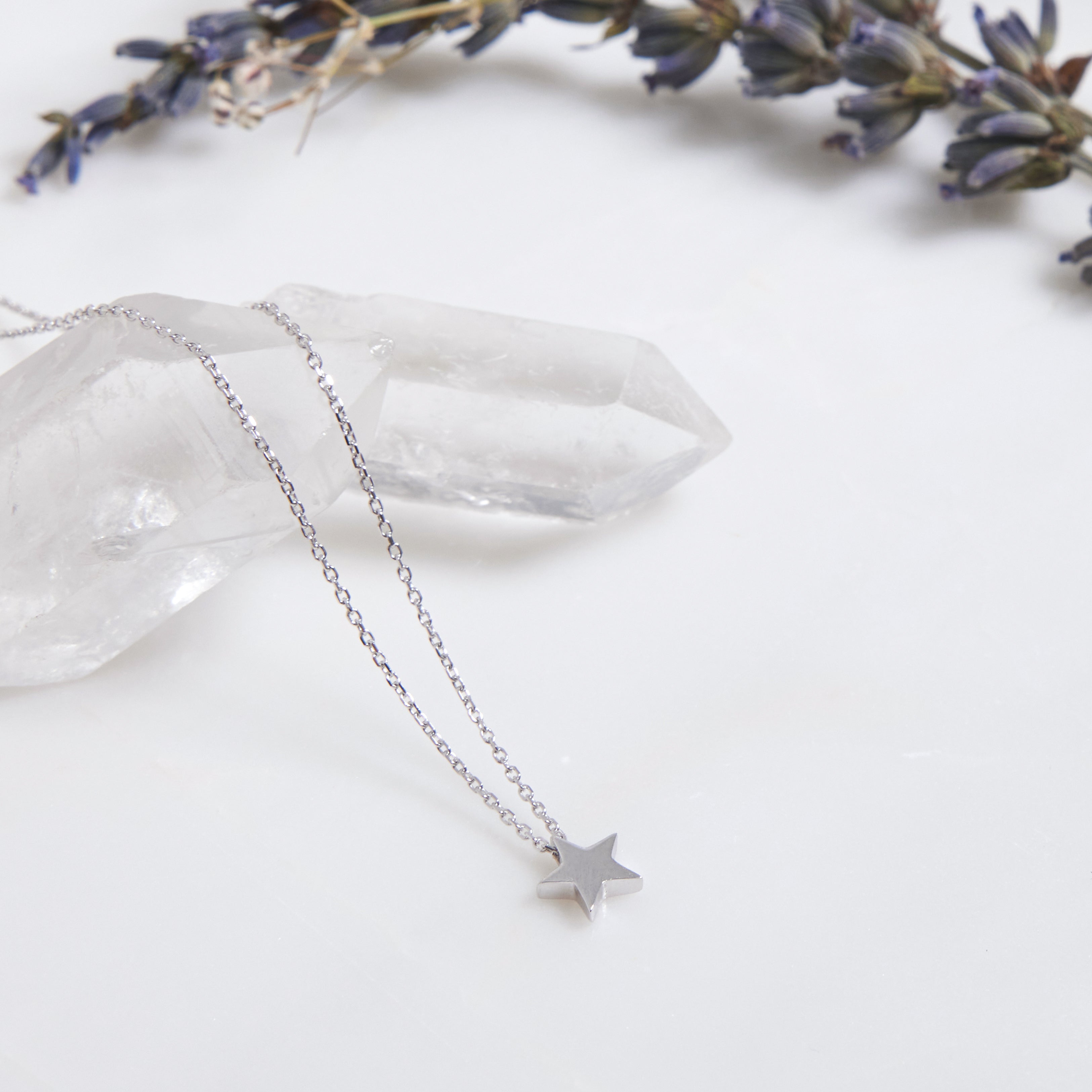 14K solid white gold minimalist star necklace on a crystal with lavender, showcasing dainty design and elegance.