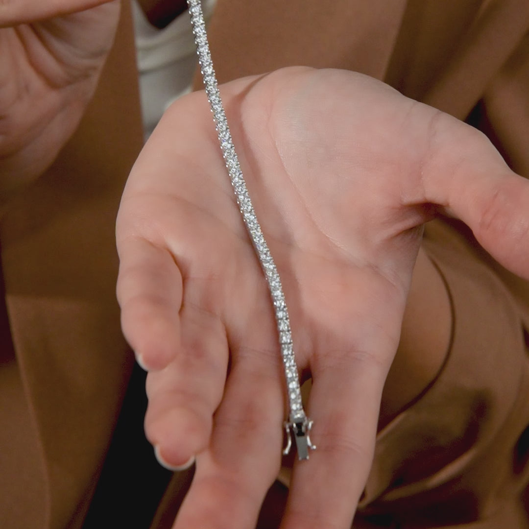 14K solid white gold diamond tennis bracelet showcased in a hand, featuring 4.10 carats of sparkling diamonds.