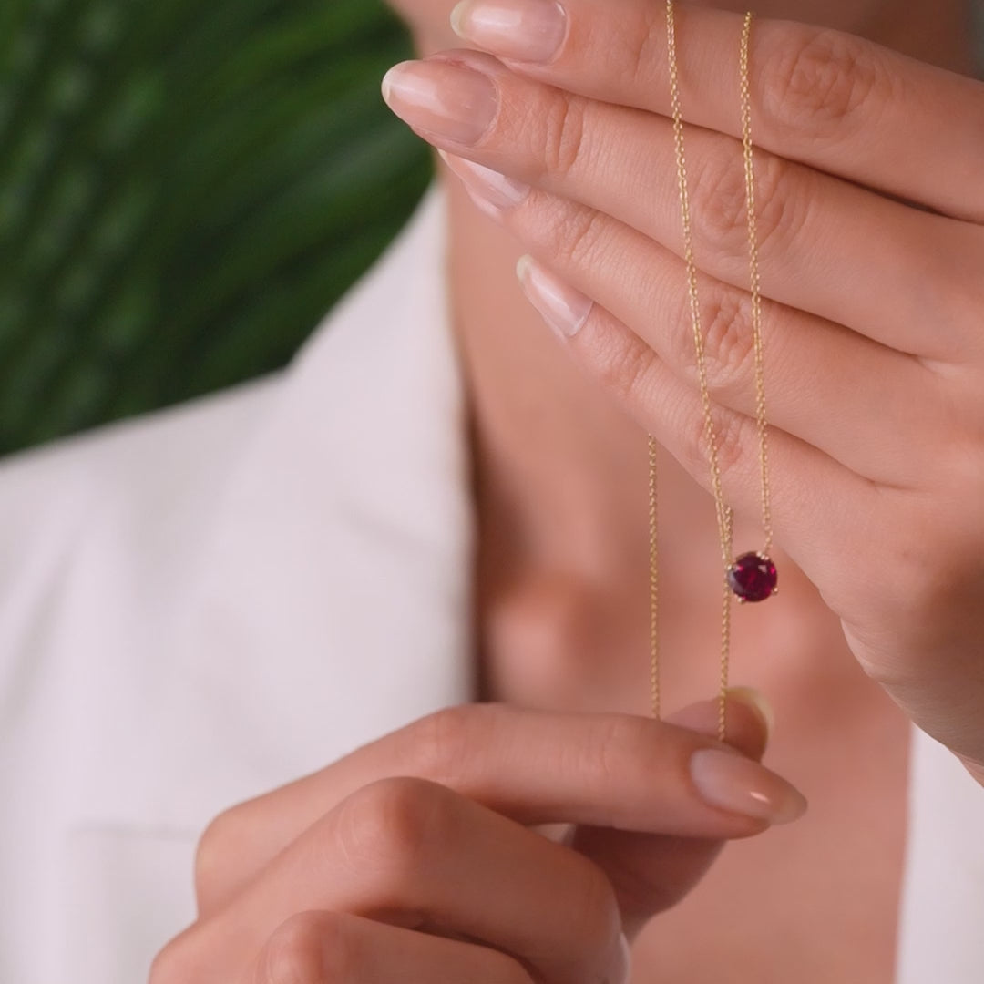 Model showcasing a 14K yellow gold 6mm prong setting ruby solitaire necklace in a minimalist design.
