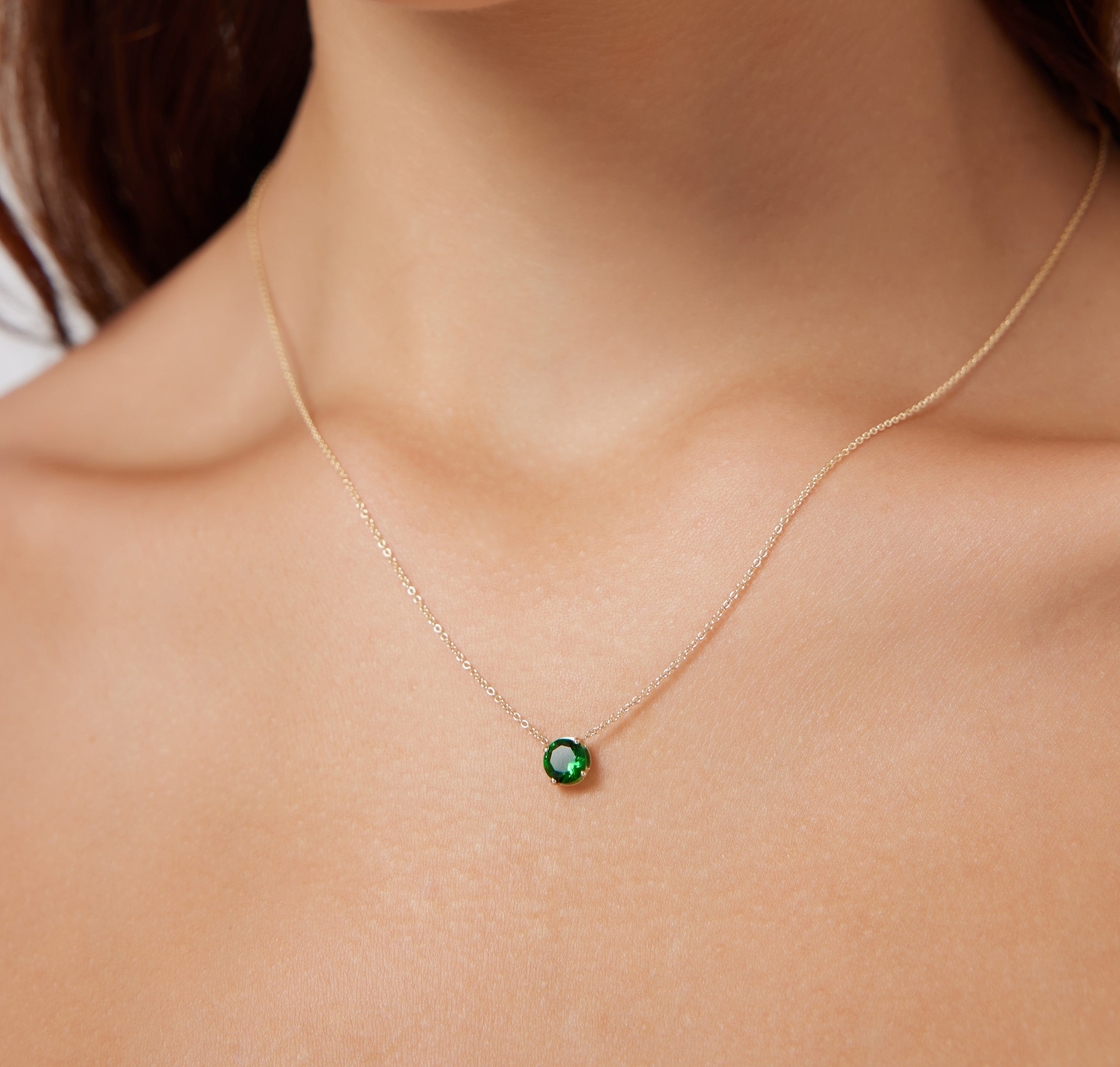 Elegant 14K white gold 6mm prong setting solitaire emerald necklace on a model, showcasing minimalist style.