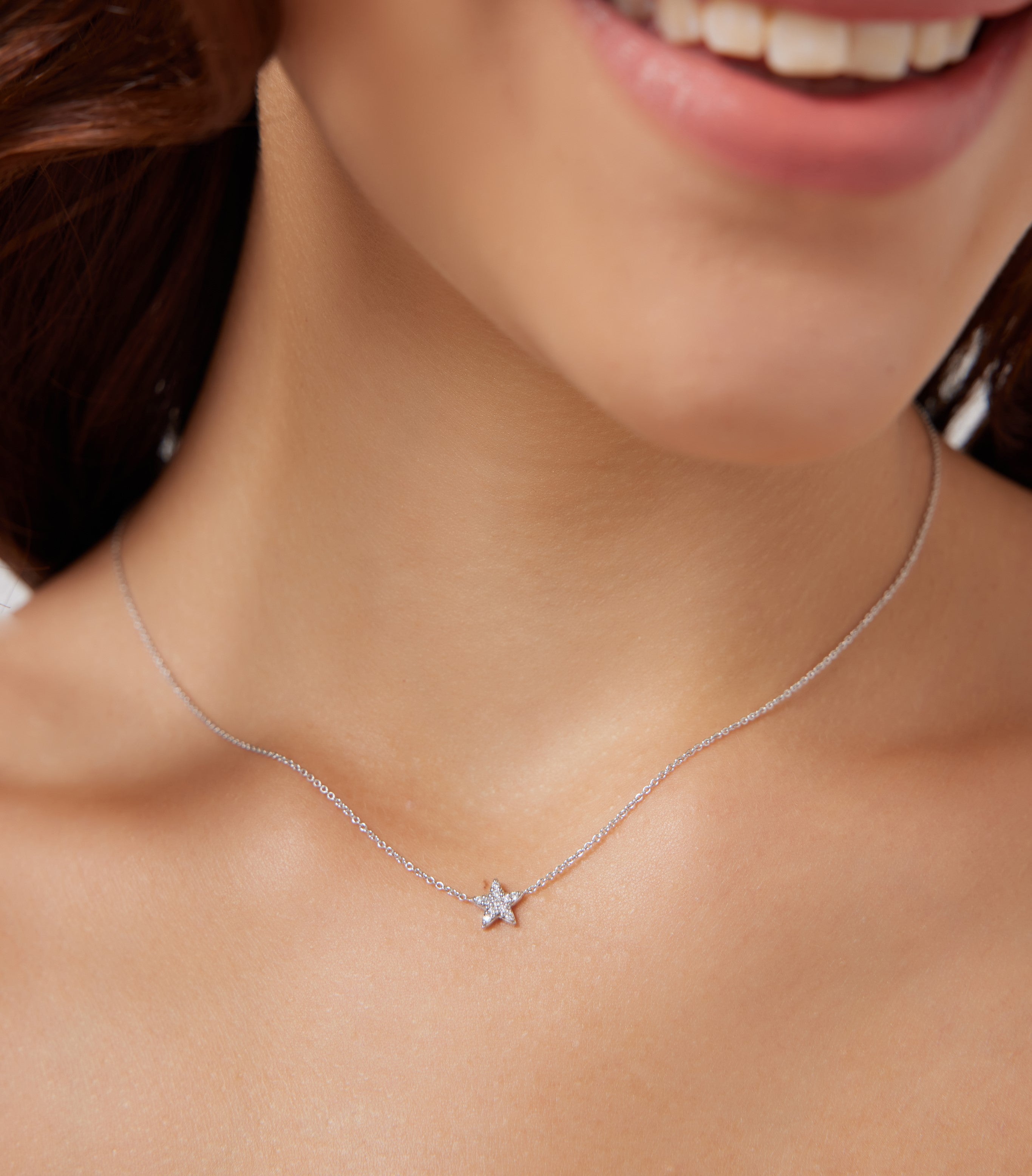Model wearing a dainty 14K solid white gold diamond star necklace, showcasing its minimalist design and sparkle.
