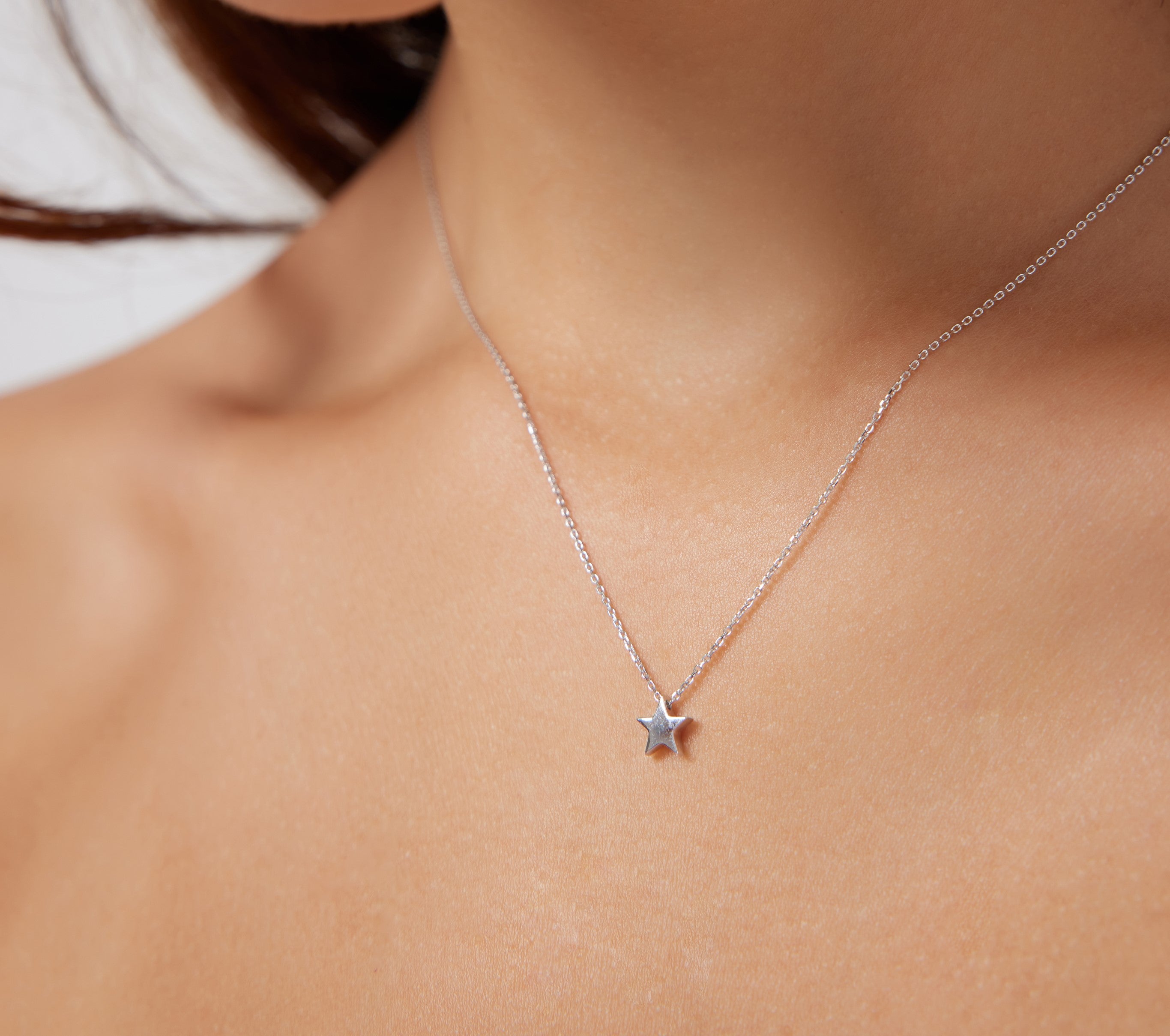 14K solid white gold minimalist star necklace displayed elegantly on a model's neck, showing delicate jewelry design.