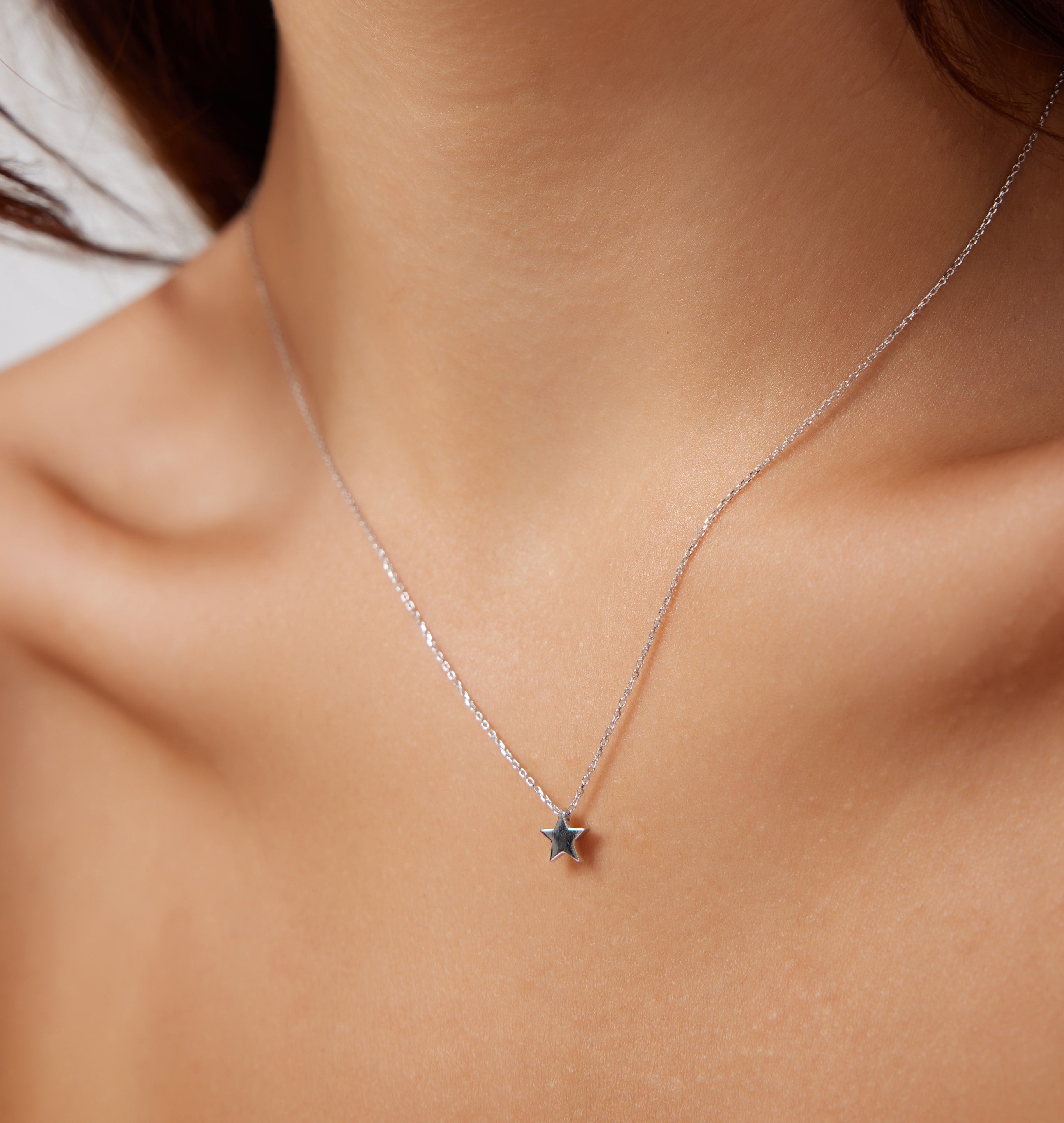 Dainty 14K solid white gold minimalist star necklace on a woman's neck, showcasing elegance and simplicity.