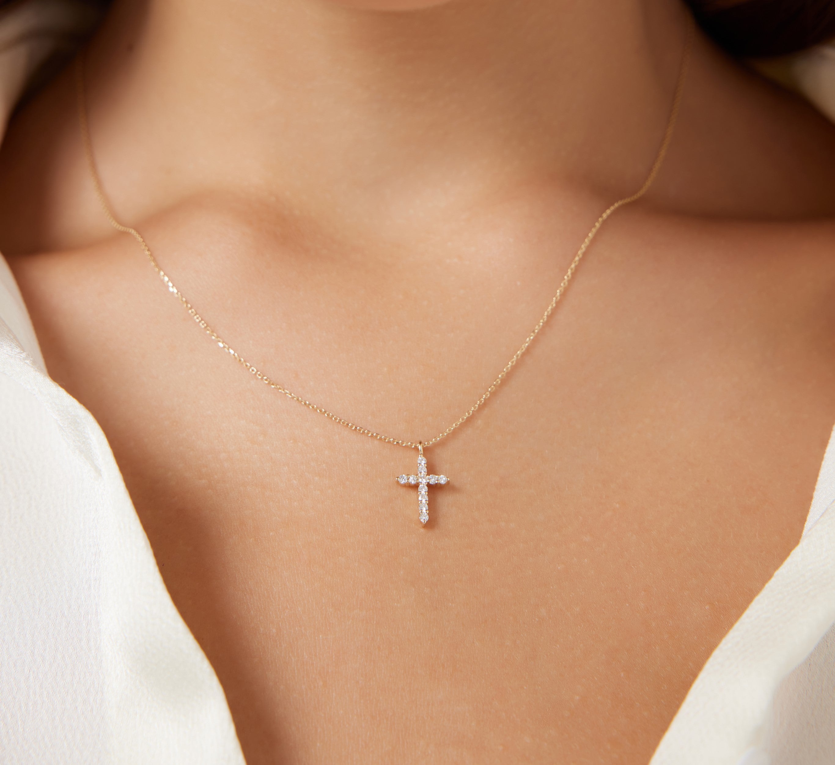 14K solid yellow gold diamond cross necklace worn on model, showcasing minimalist design and natural diamond sparkle.