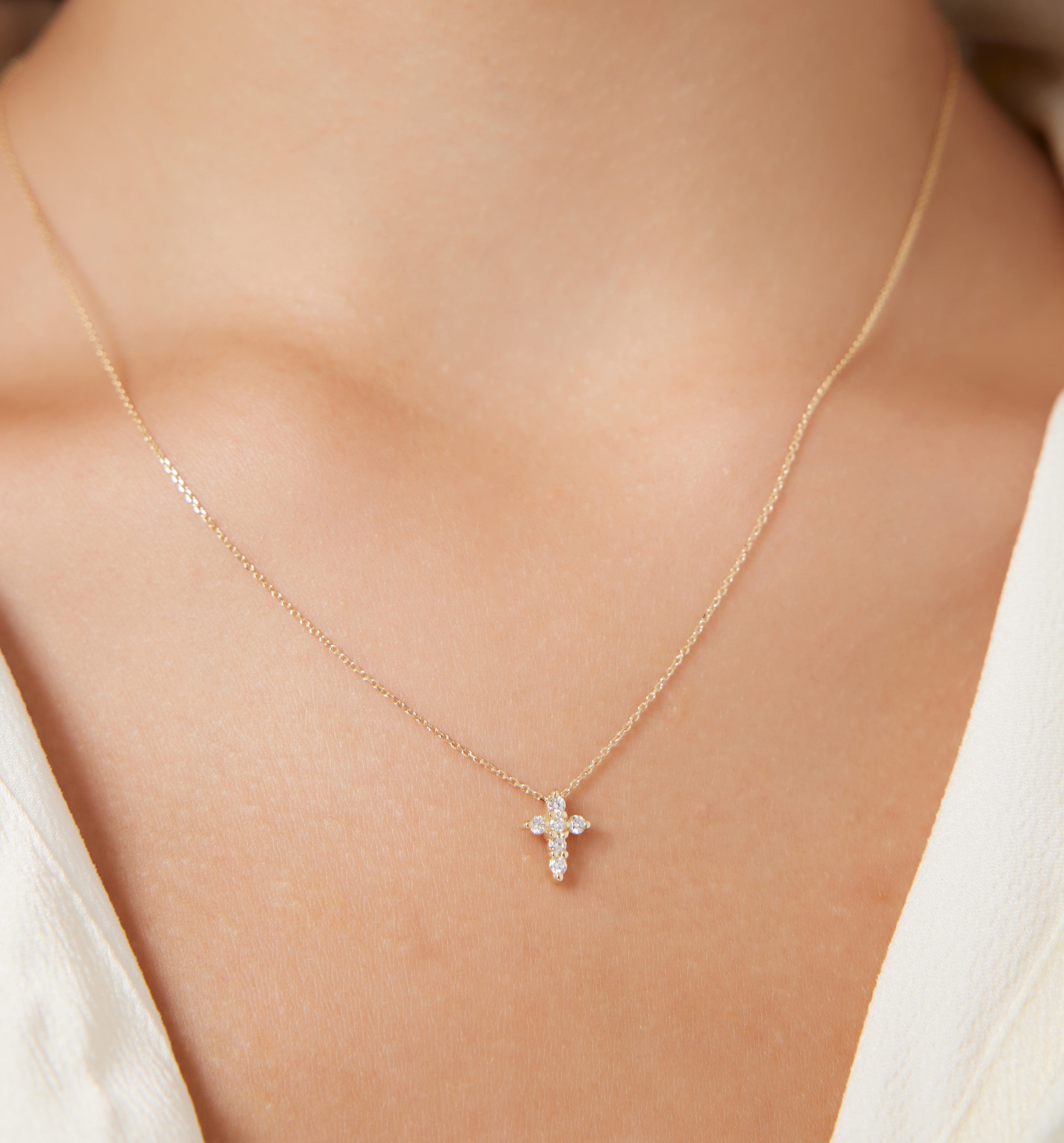 14K solid white gold minimalist diamond cross necklace worn, showcasing dainty design with sparkling diamonds.