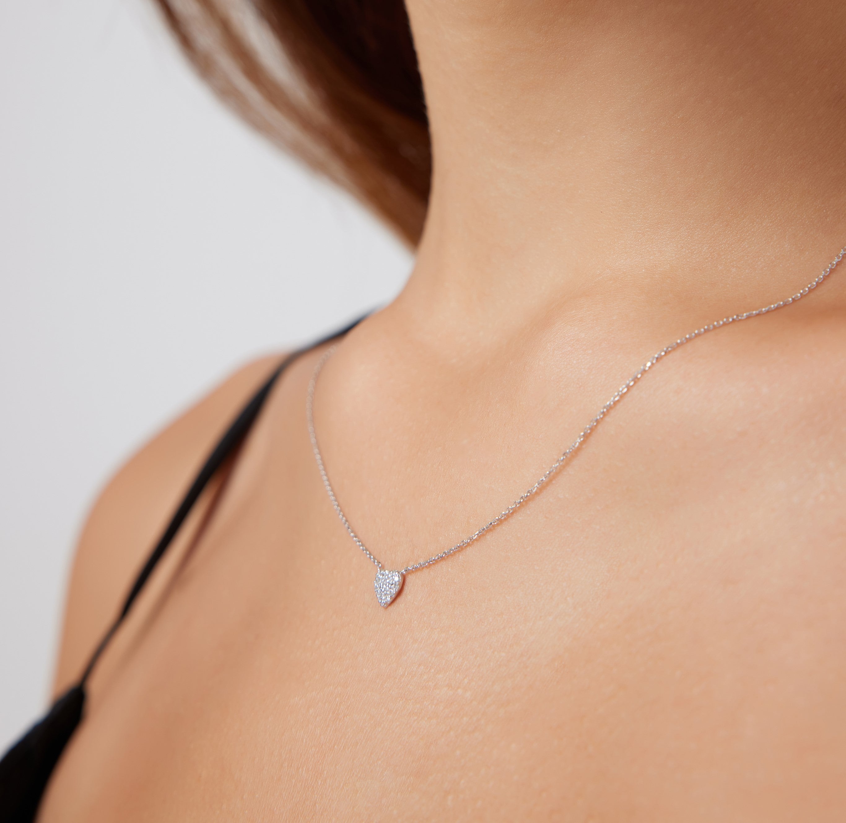 Model wearing a 14K solid white gold minimalist diamond heart necklace, showcasing its elegant design.