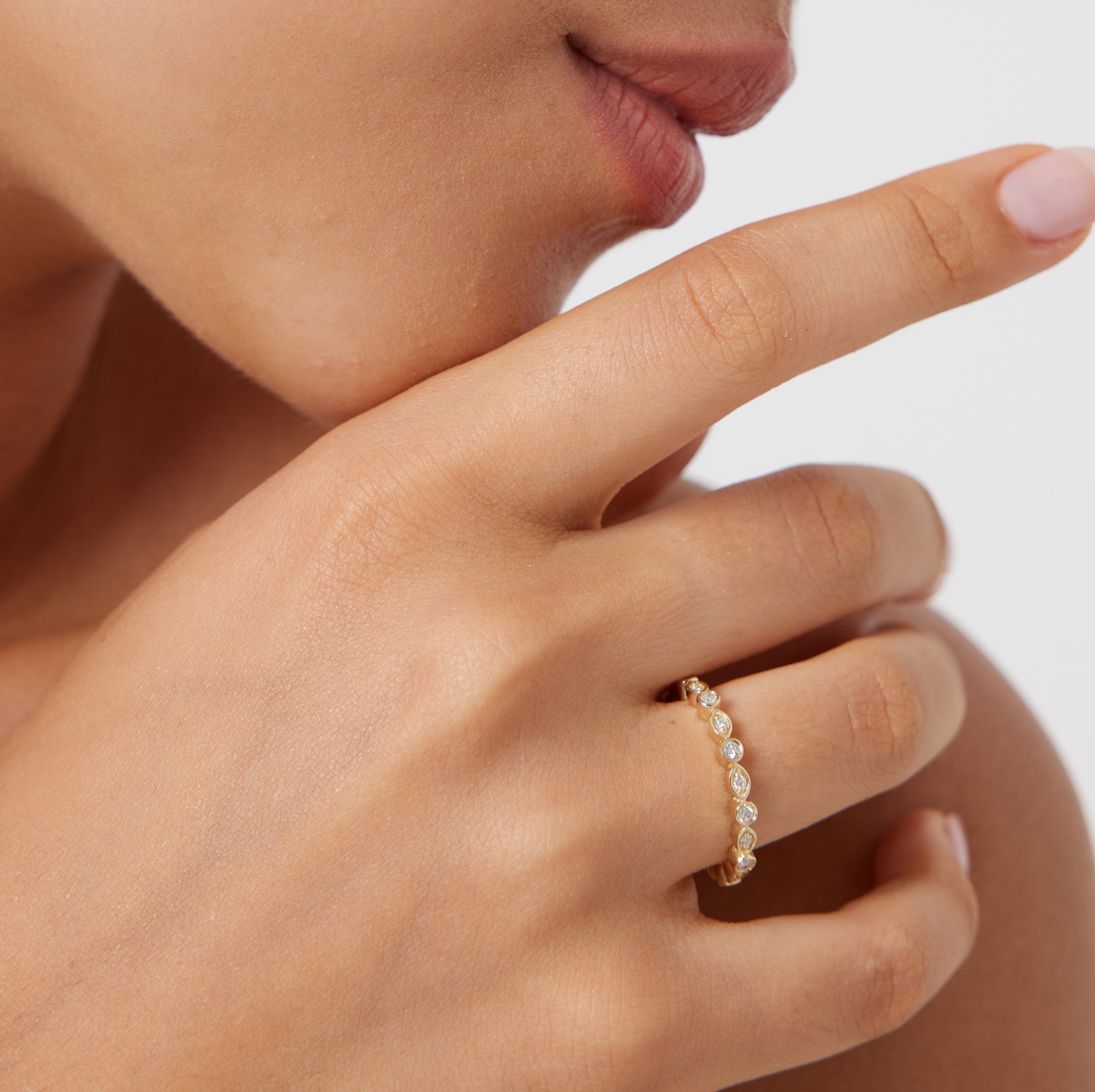 14K gold women's full eternity diamond wedding ring worn on a finger, showcasing sparkling round diamonds and a shiny finish.