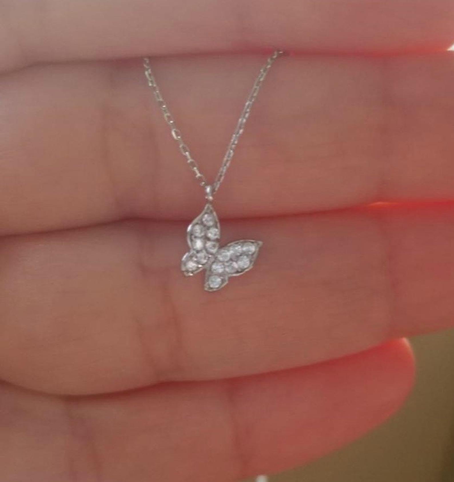 Dainty 14K solid white gold minimalist butterfly necklace with CZ in hand, perfect for everyday wear.