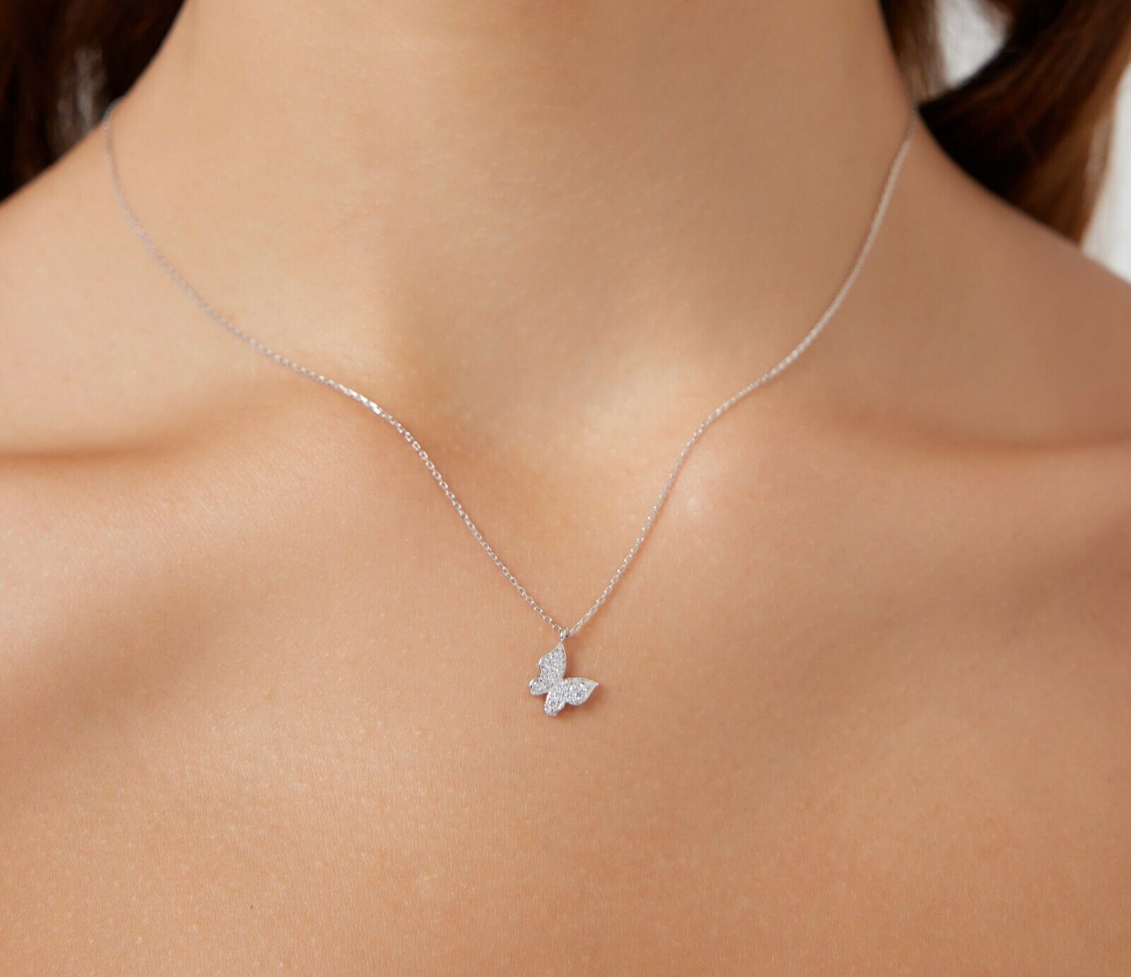 14K solid white gold minimalist butterfly necklace worn on a model's neck, featuring a delicate dainty design.