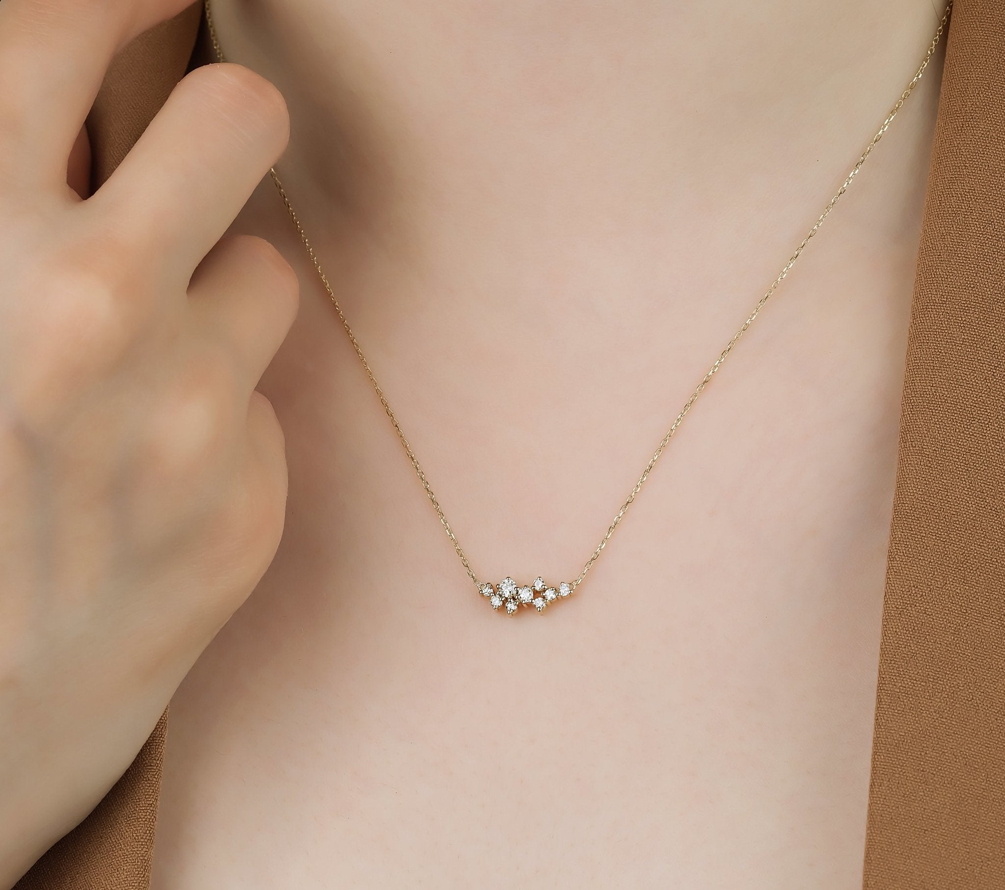 Dainty 14K gold diamond cluster necklace with nine sparkling diamonds on a delicate chain.