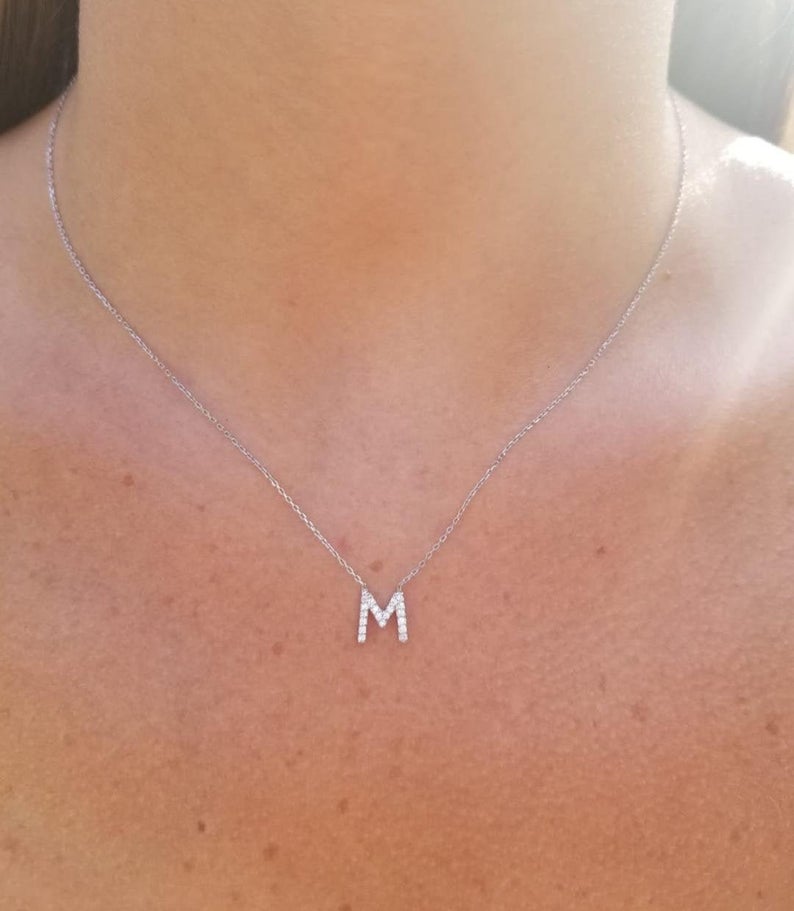 14K white gold letter M initial necklace with diamonds, worn around the neck, showcasing sparkle and elegance.