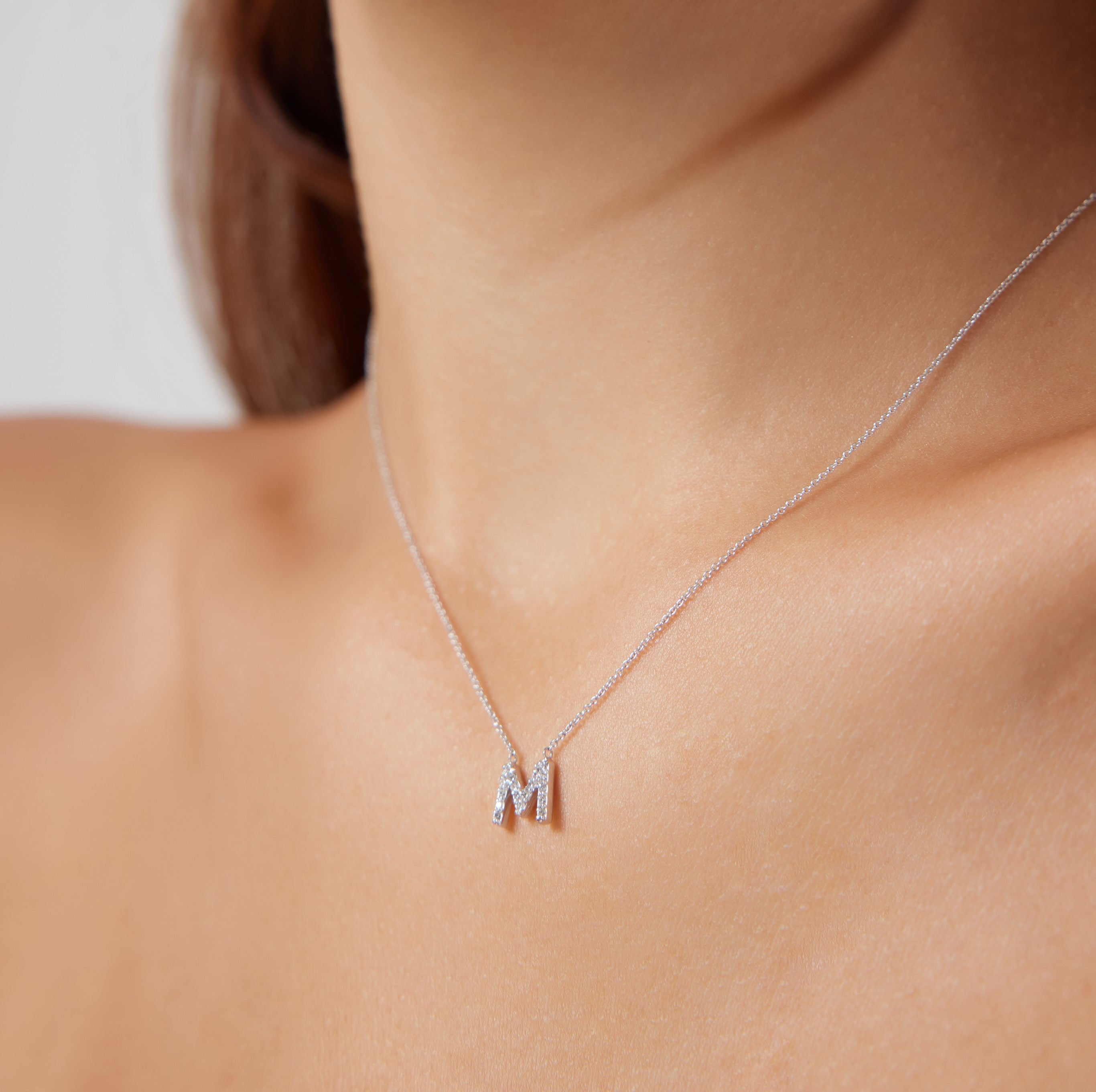 14K white gold diamond letter M necklace on model, dainty initial jewelry with sparkling diamonds.