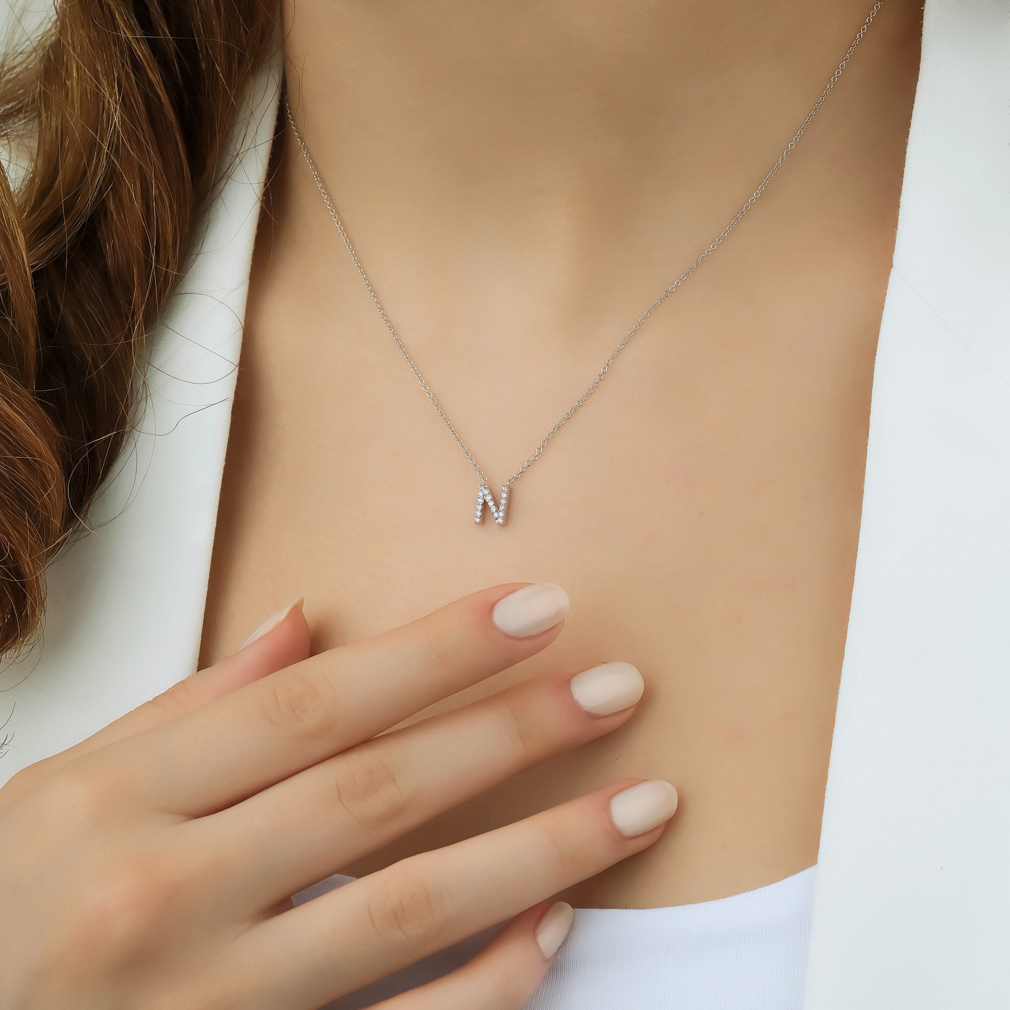 14K white gold diamond letter N necklace worn by a model, showcasing elegant design and sparkle.