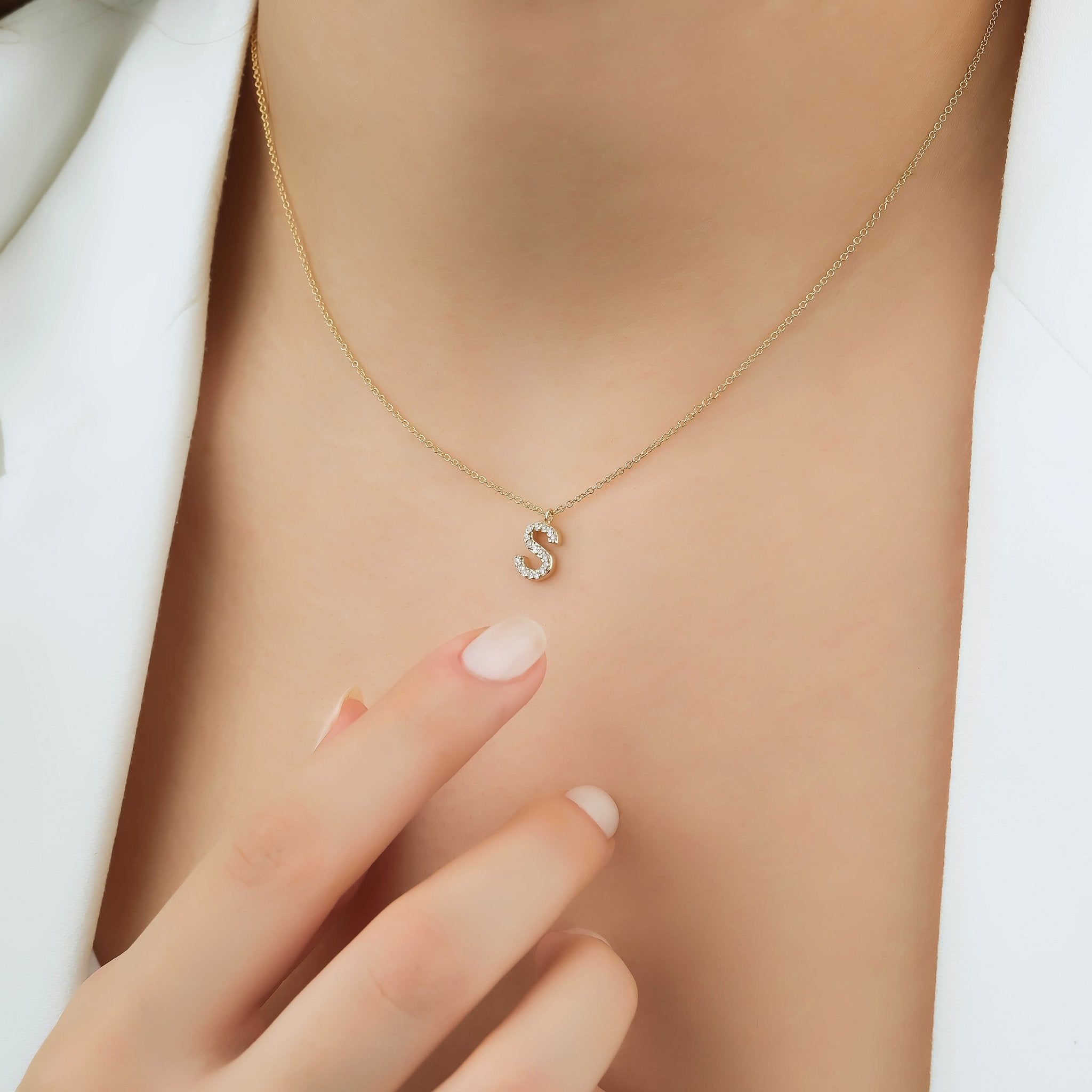 14K white gold diamond initial necklace featuring letter S, worn by a woman, showcasing dainty elegance.