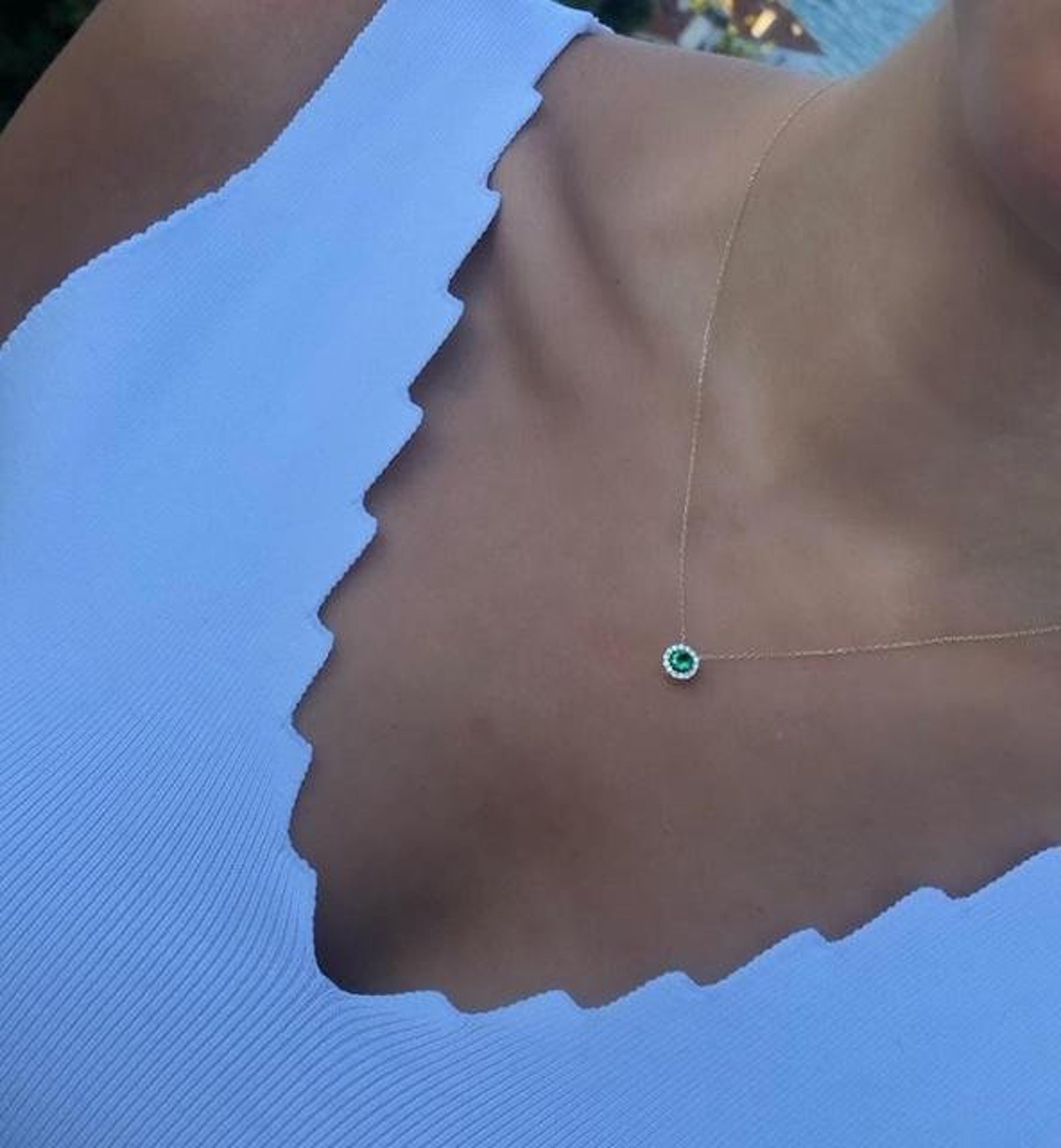 14K solid yellow gold minimalist solitaire emerald necklace on a person, elegant and classy for everyday wear.
