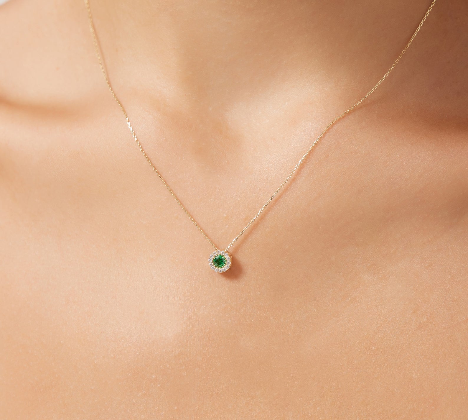 14K solid yellow gold minimalist solitaire emerald necklace worn on a neck, featuring a dainty design with CZ accent.