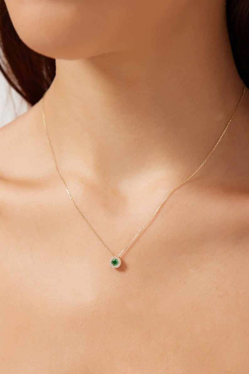 14K solid yellow gold minimalist solitaire emerald necklace with CZ worn by a model, showcasing elegance and simplicity.