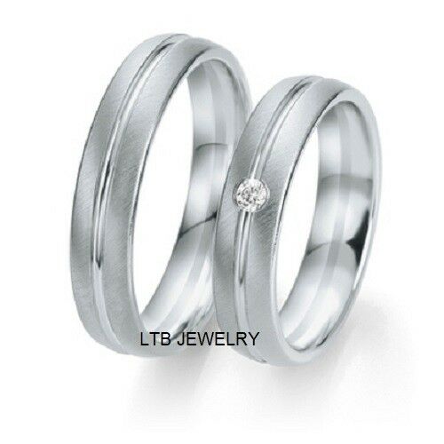 His and hers platinum diamond wedding bands featuring brushed and shiny finish with accent diamond on her band.