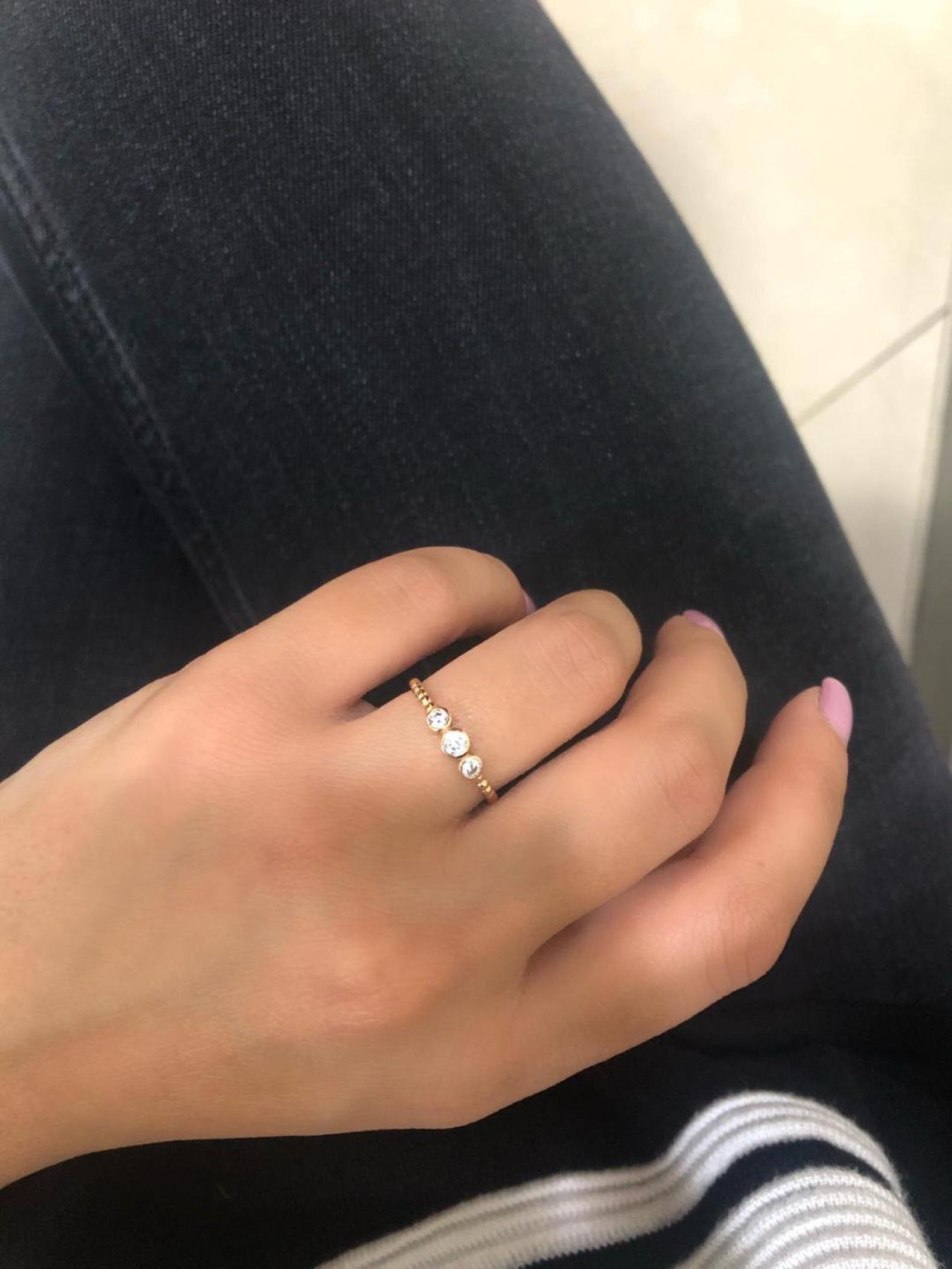 Elegant 14K gold trio diamond ring showcased on a hand, featuring sparkling white diamonds and a sleek design.