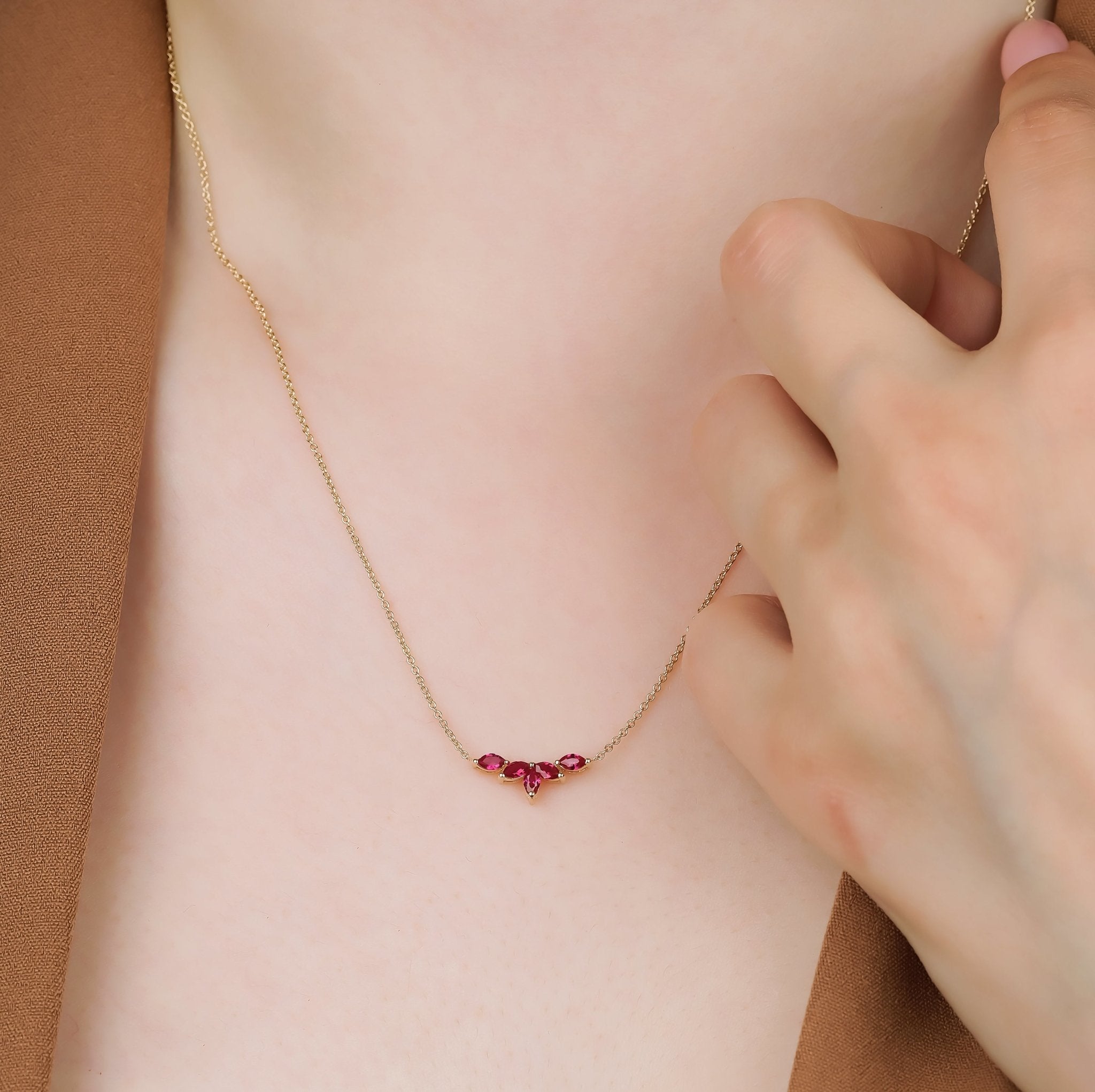14K Gold Cluster Marquise Ruby Necklace worn by a woman, showcasing its delicate design and vibrant ruby gemstones.