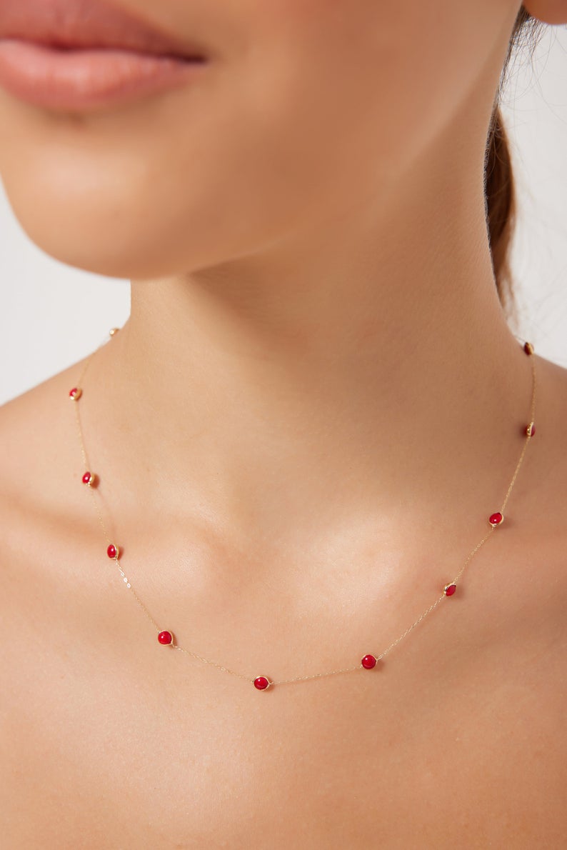 Dainty 14K solid yellow gold beaded station ruby necklace on model, showcasing July birthstone elegance.