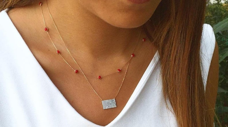 14K solid yellow gold beaded station ruby necklace worn by model, featuring minimalist design and lab-created rubies.