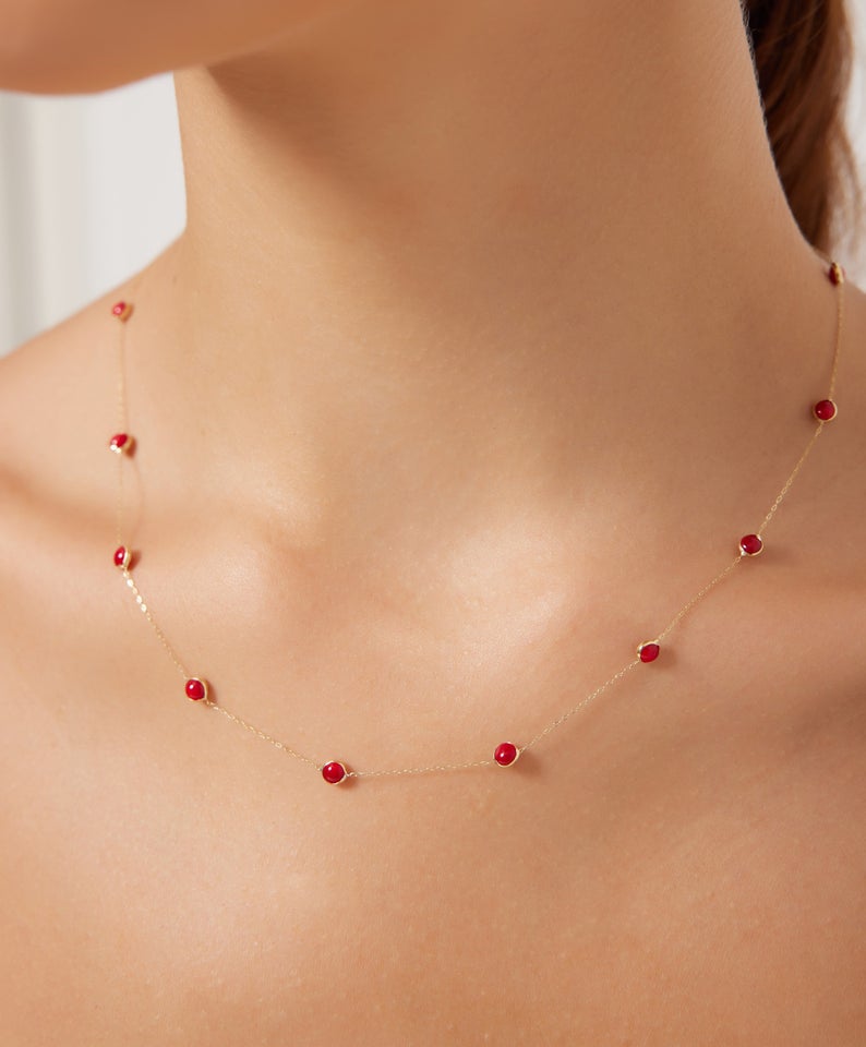 Delicate 14K solid yellow gold beaded station ruby necklace on a model, showcasing minimalist design and July birthstone elegance.