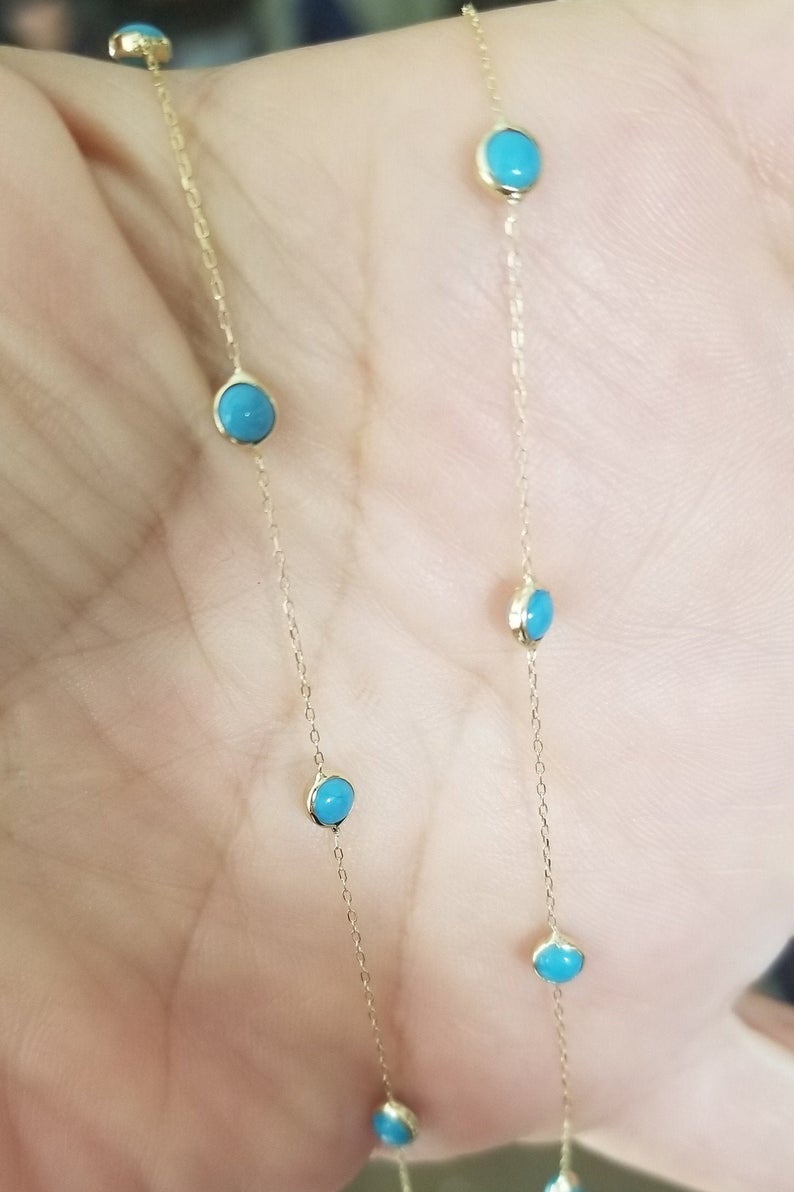 14K solid yellow gold beaded station turquoise necklace displayed on hand, featuring minimalist design and vibrant turquoise beads.