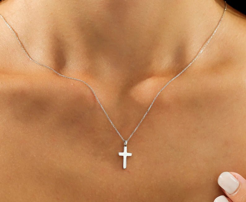 14K solid white gold cross necklace worn on a model, showcasing a delicate and minimalist design.