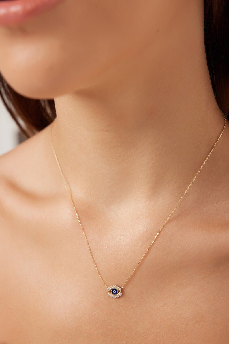 18K solid yellow gold evil eye necklace worn by a model, highlighting its delicate and minimalist design.