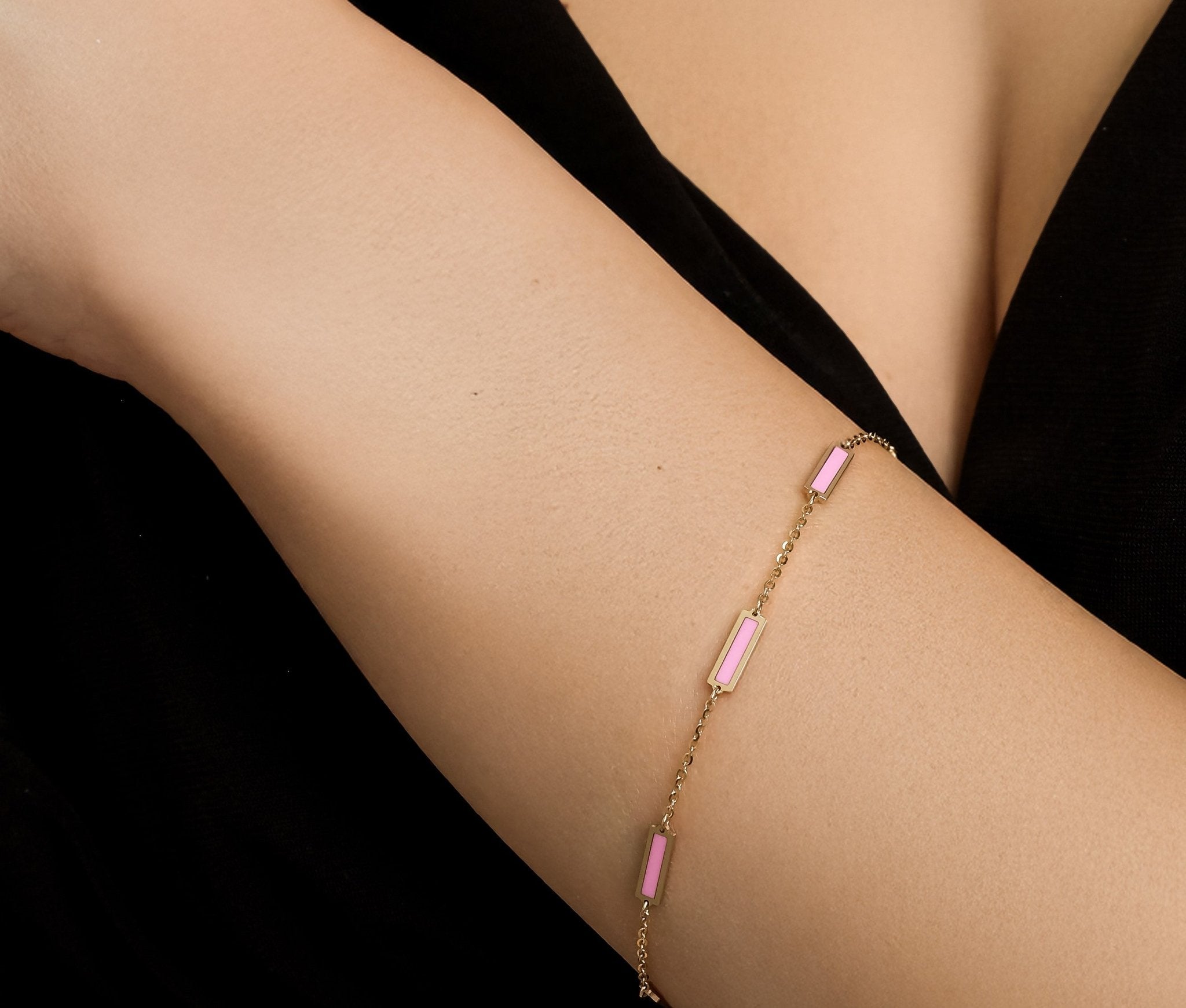 14K solid yellow gold pink bar bracelet displayed on a model's wrist, showcasing its elegant design.