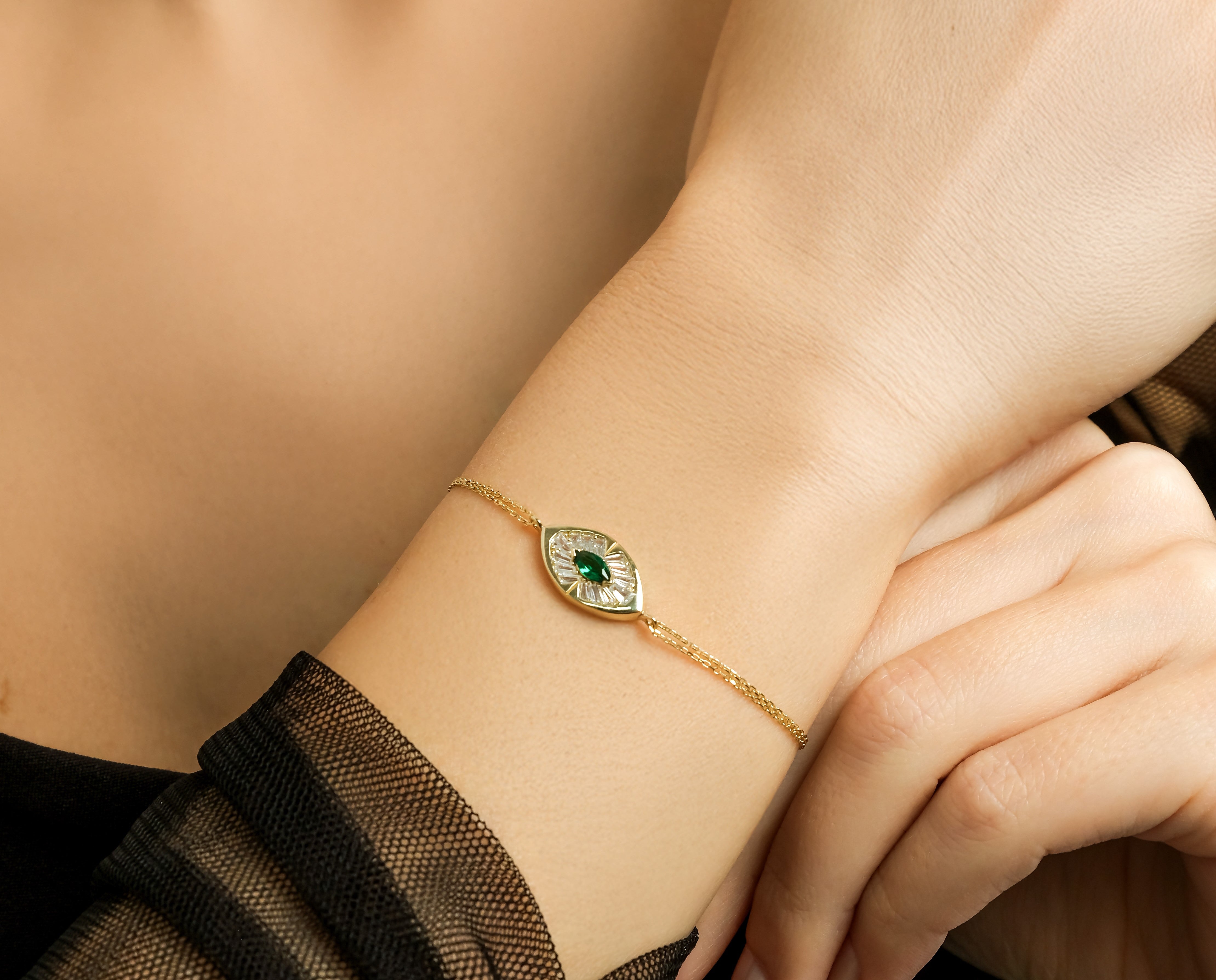 Dainty 14K solid yellow gold marquise emerald bracelet worn on wrist with CZ stones.