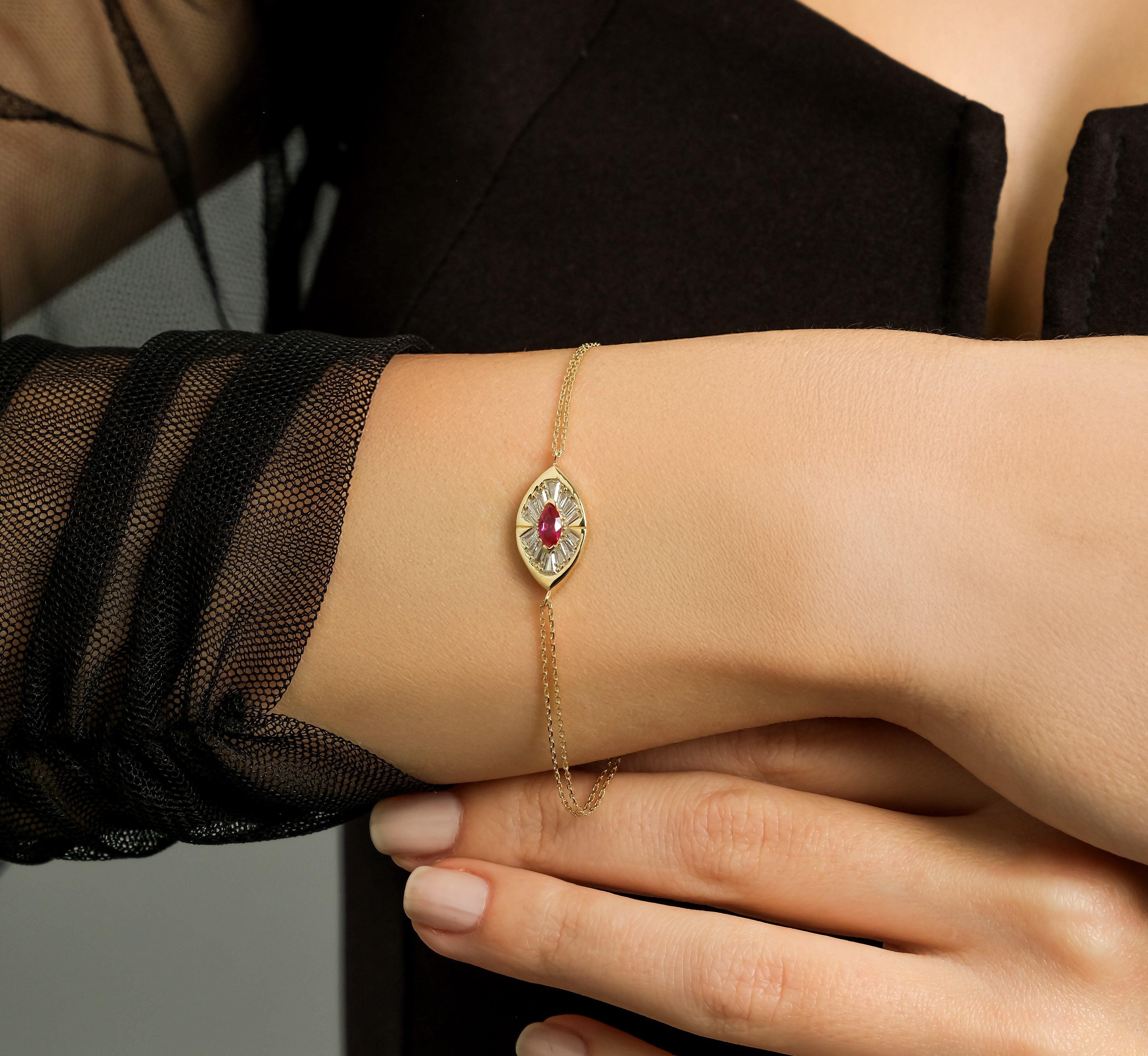 14K solid yellow gold marquise ruby bracelet worn on a woman's wrist, elegantly showcasing its CZ stones.