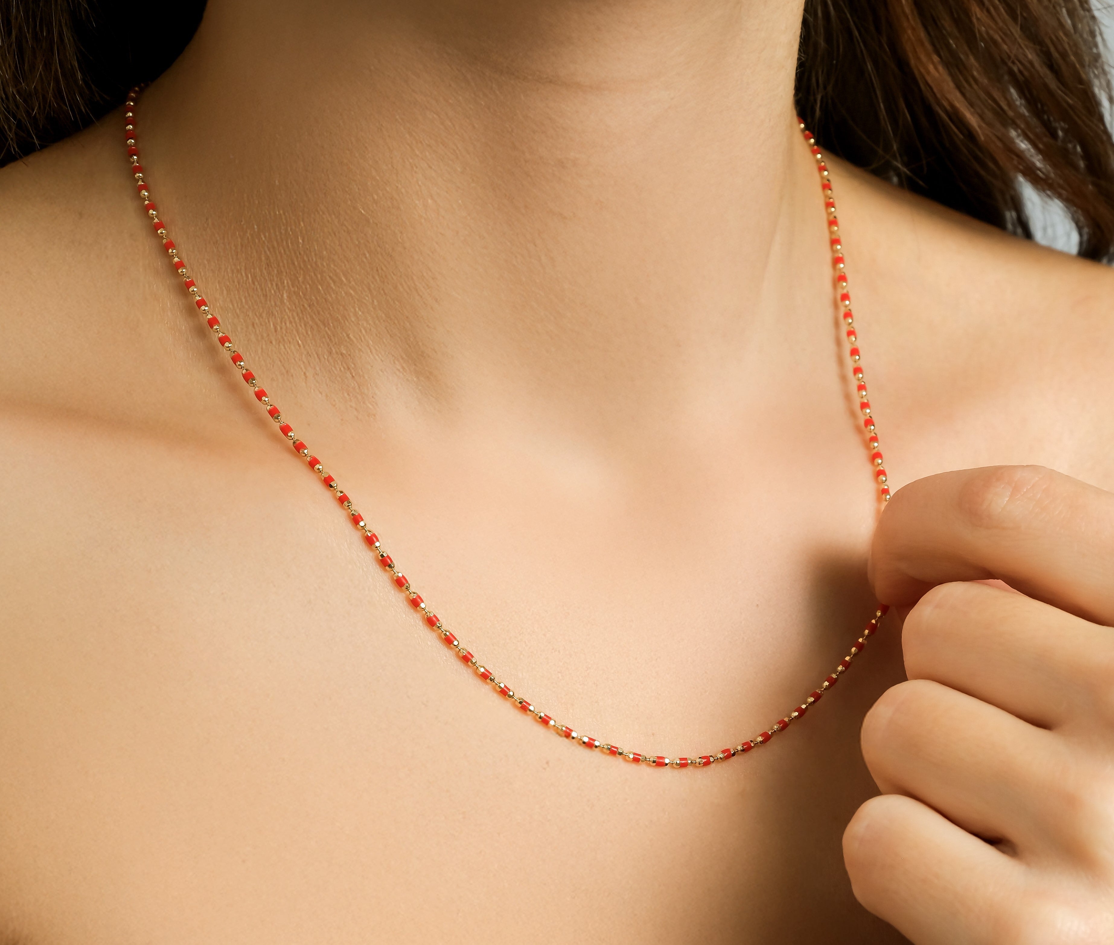14K solid yellow gold red enamel beaded necklace worn elegantly, showcasing its dainty design and minimalist style.