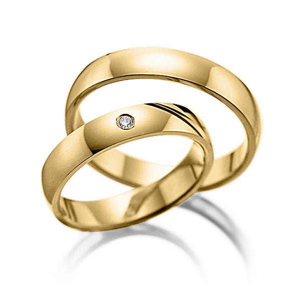 His and hers plain wedding bands in yellow gold, featuring a diamond in her band, showcasing a shiny finish and comfort fit.