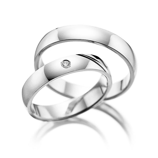 His and hers plain wedding rings in white gold with shiny finish and a diamond accent on her band.