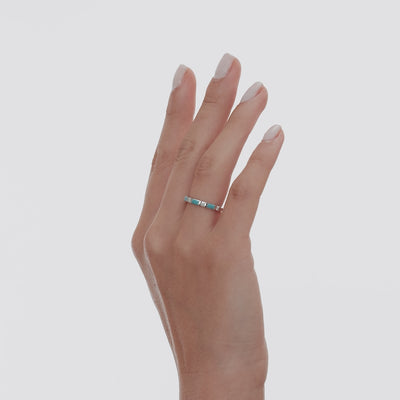 Dainty 14K solid white gold wedding ring featuring turquoise and diamonds, elegantly displayed on a model's hand.