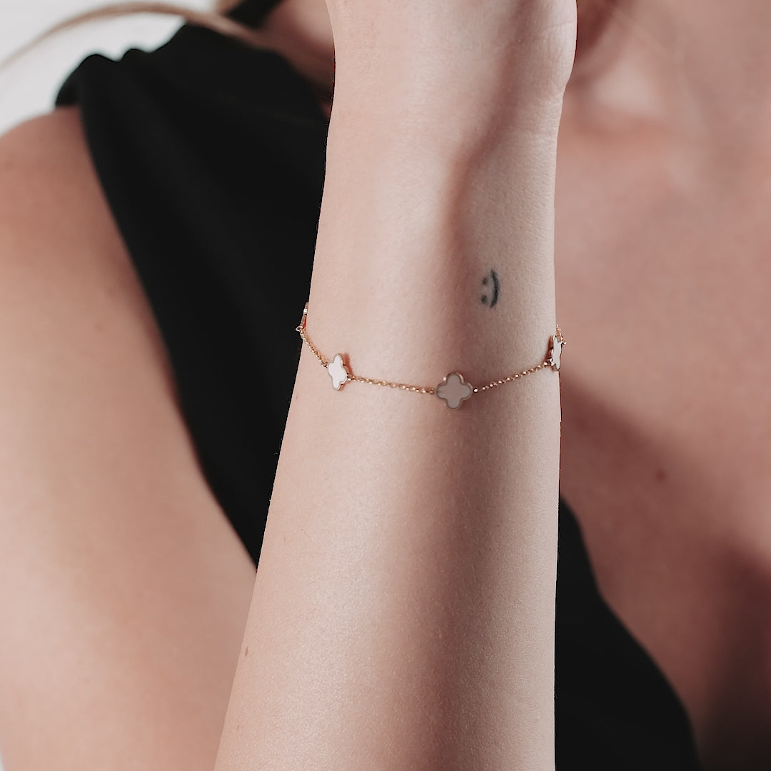 14K solid yellow gold pink four leaf clover bracelet worn on wrist, featuring delicate design and elegant style.