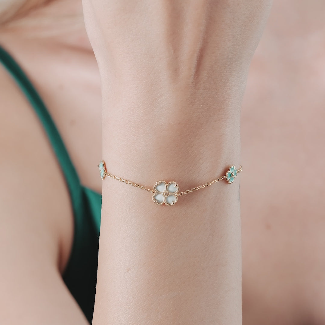 14k yellow gold four leaf clover bracelet with mother of pearl accent on a woman's wrist.