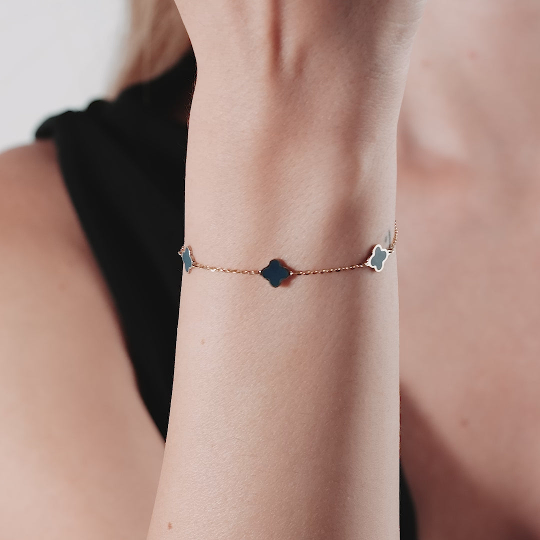 14K solid yellow gold onyx four leaf clover bracelet worn on wrist, showcasing its delicate design and elegant shine.