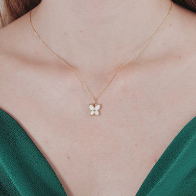 14K solid yellow gold dainty butterfly necklace worn on a woman's neck, showcasing its elegant design.