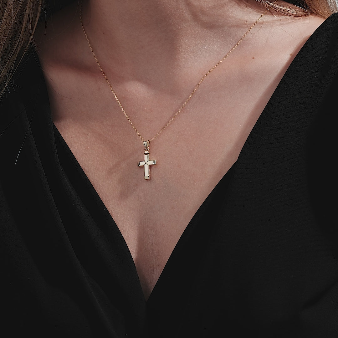 14K yellow gold minimalist cross necklace worn on a model, capturing a delicate and elegant style.