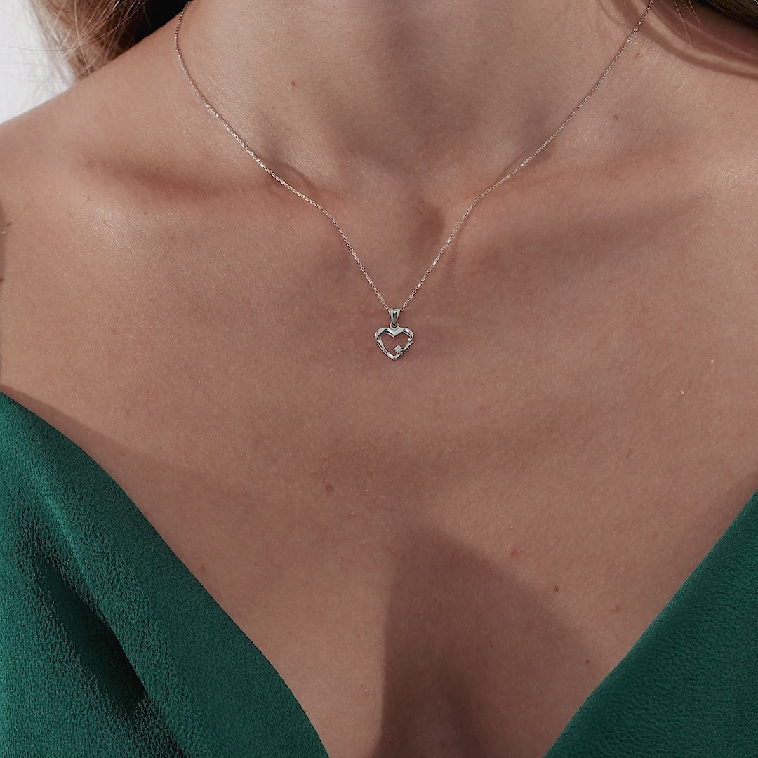 Dainty 14K solid white gold diamond heart necklace worn by a model with a green top, highlighting its elegance.