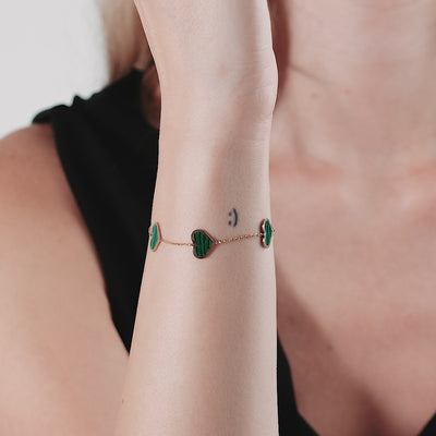 14K solid yellow gold station malachite heart bracelet worn on wrist, showcasing vibrant green hearts and elegant design.